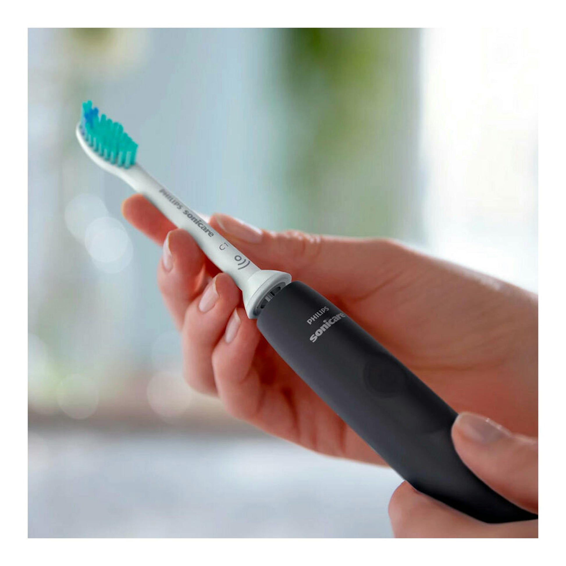 Cepillo dental eléctrico Philips Sonicare HX3671/14 negro, sostenido con la mano, vista en primer plano.