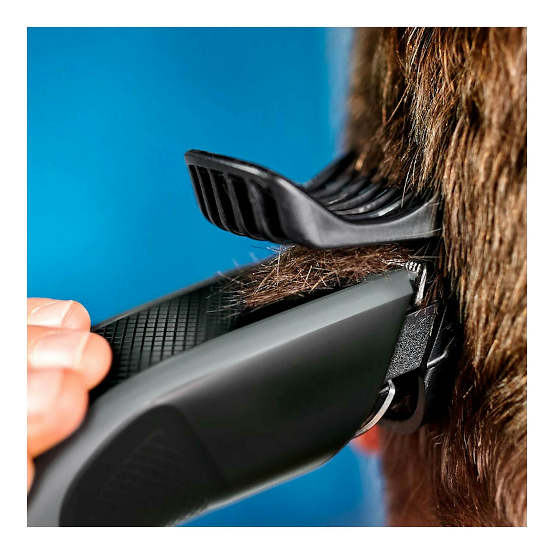 Cortapelos Philips HC3525/15 negro en primer plano, vista lateral, cortando el cabello con peine guía.