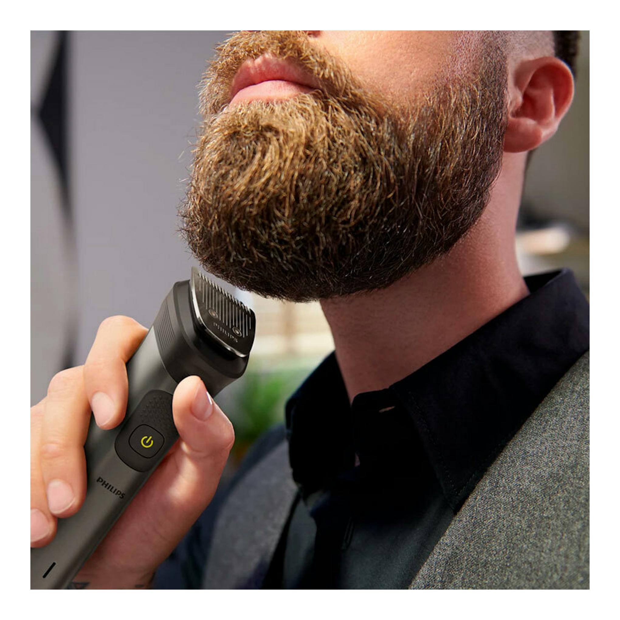 Cortapelos Philips MG7940/15 negro, en primer plano, recortando la barba de un hombre.