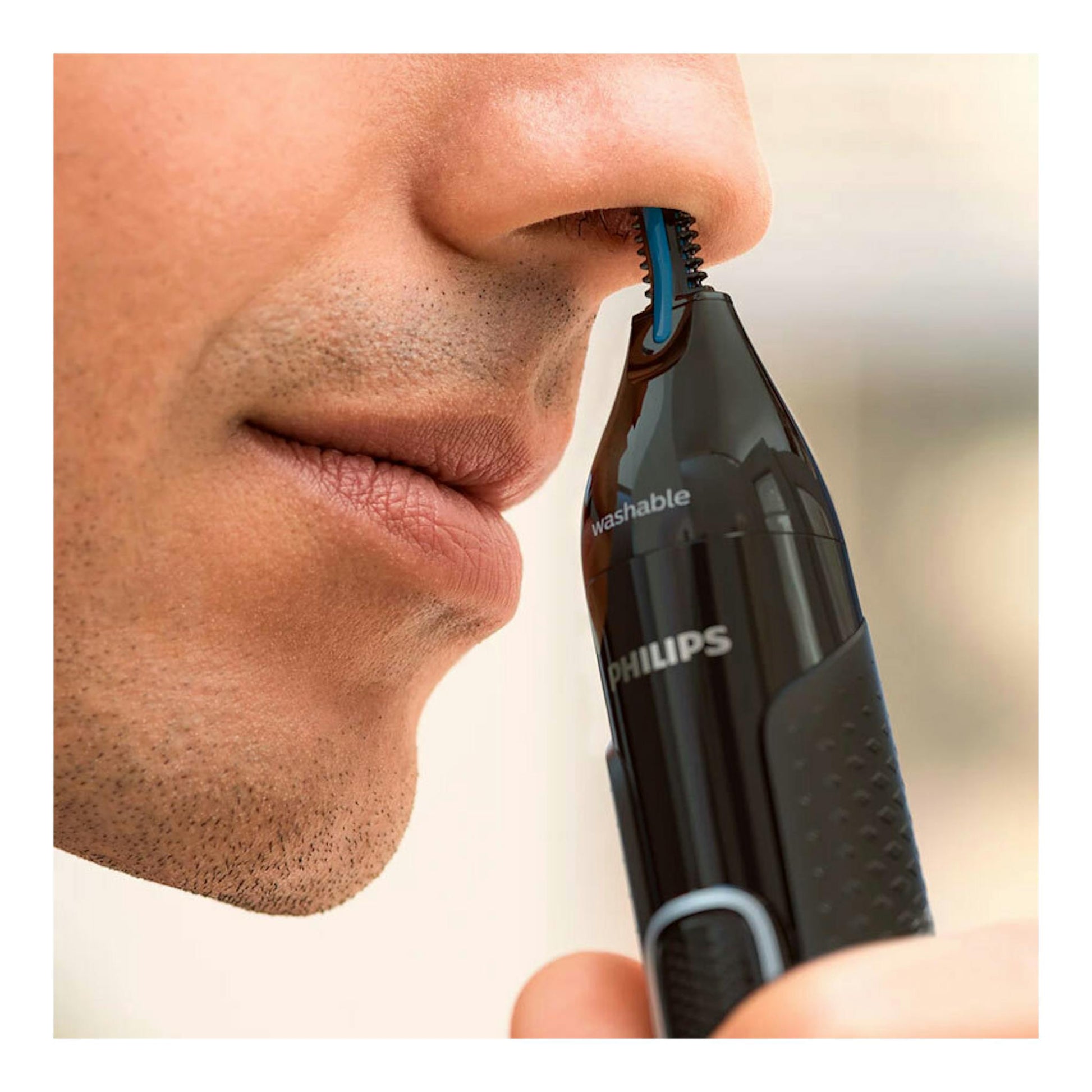 Cortapelos de nariz Philips NT5650/16 negro en primer plano, junto a la nariz de un hombre.