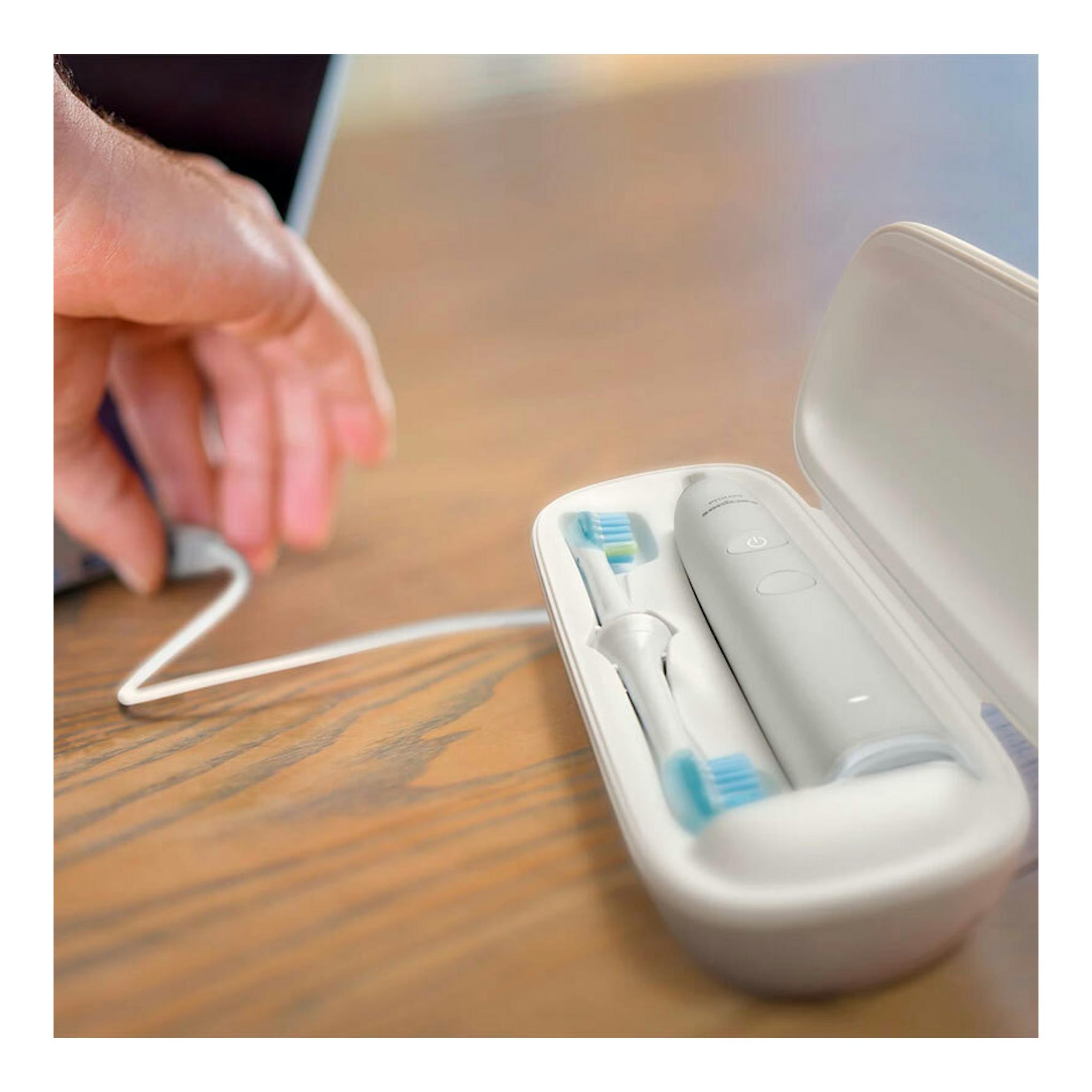 Cepillo dental Philips HX9913/17 blanco en estuche abierto, con dos cabezales y una mano junto al cable.