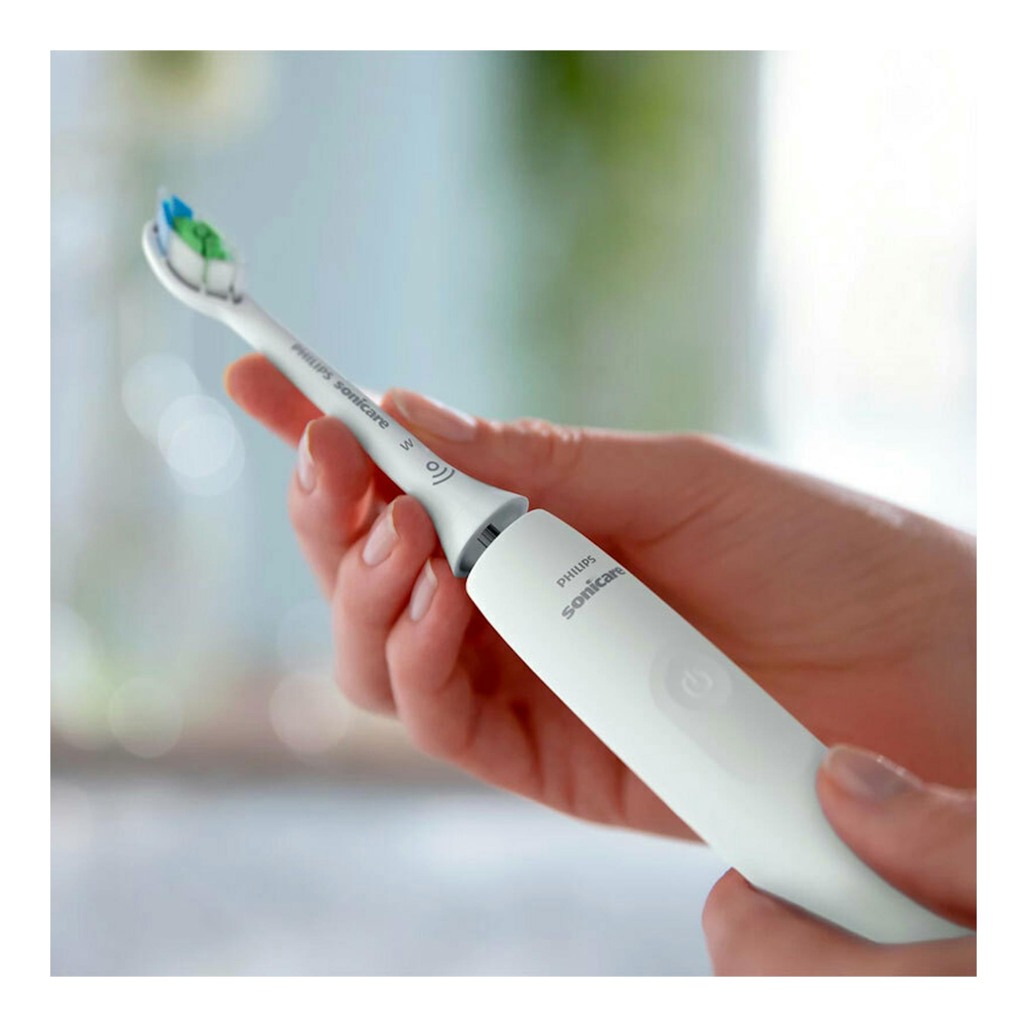 Cepillo dental eléctrico Philips Sonicare HX3681/33 blanco, sujetado con la mano en vista frontal.