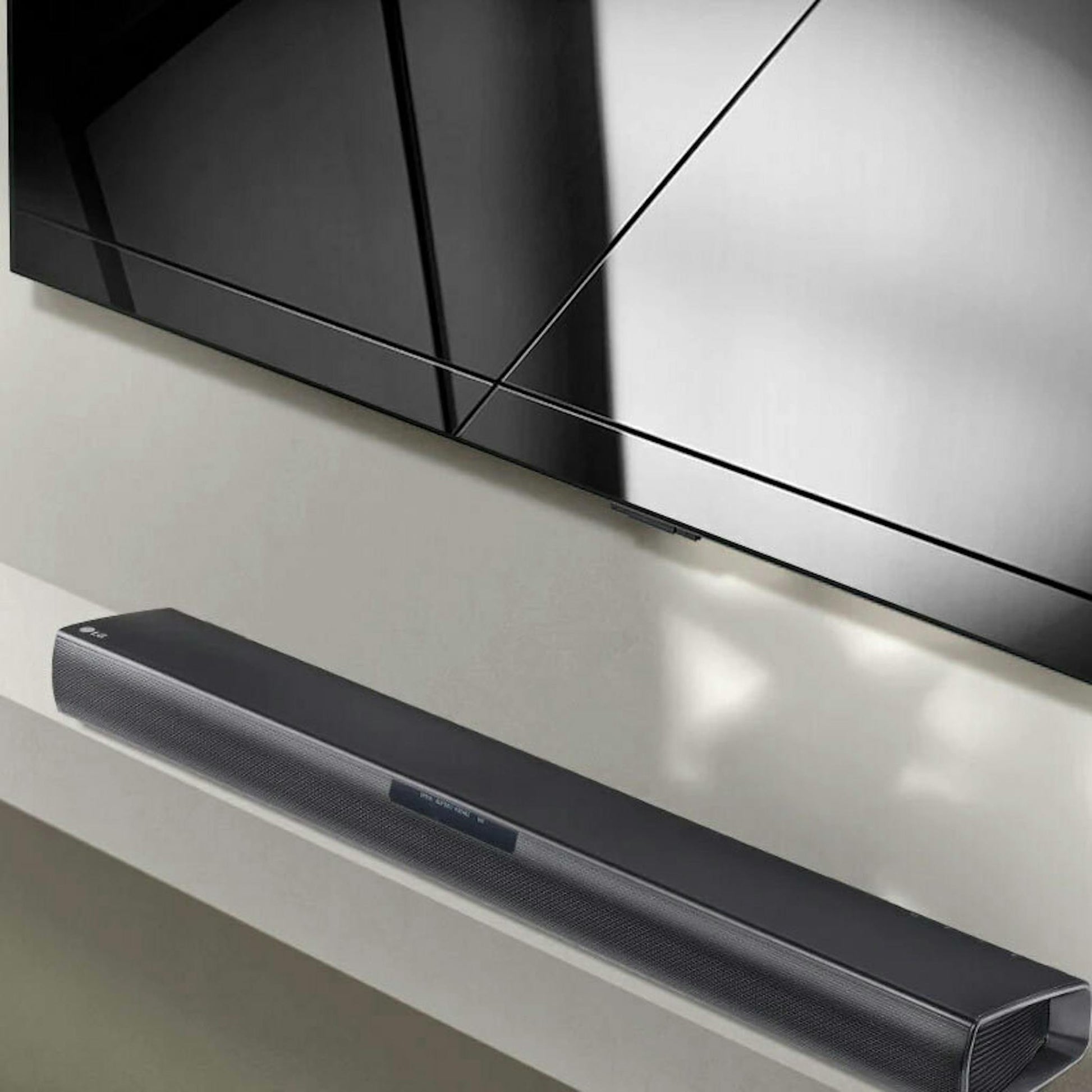 Barra de sonido LG SQC1 negra debajo de un televisor