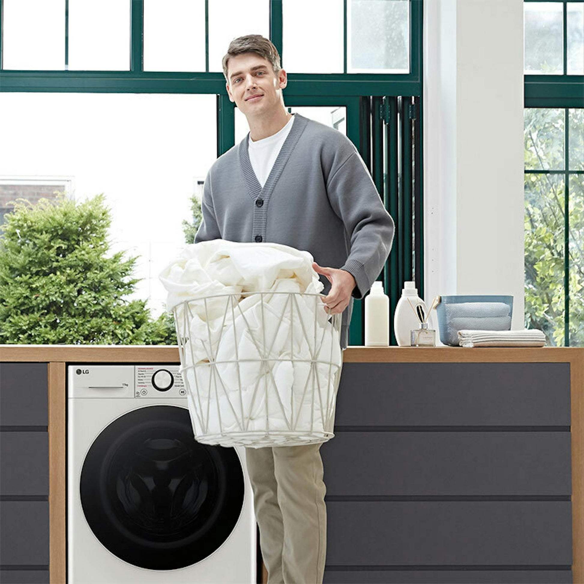 Lavadora LG F4WR6011A0W de carga frontal con una persona y cesta de ropa