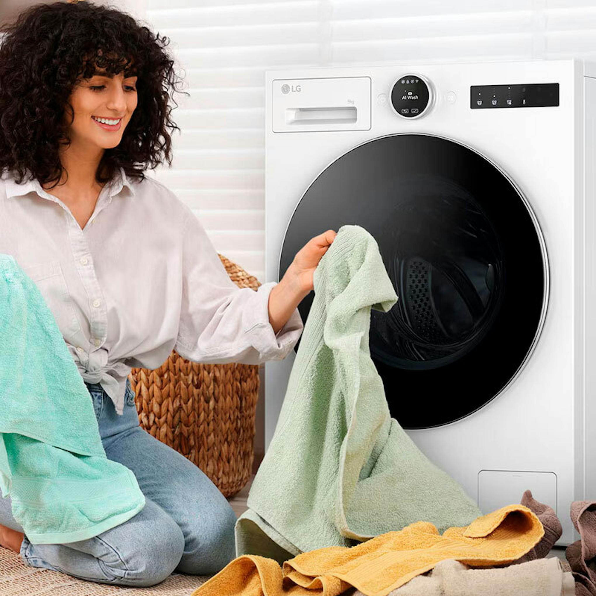 Lavadora de carga frontal LG F4X9009TWCE con una mujer colocando ropa