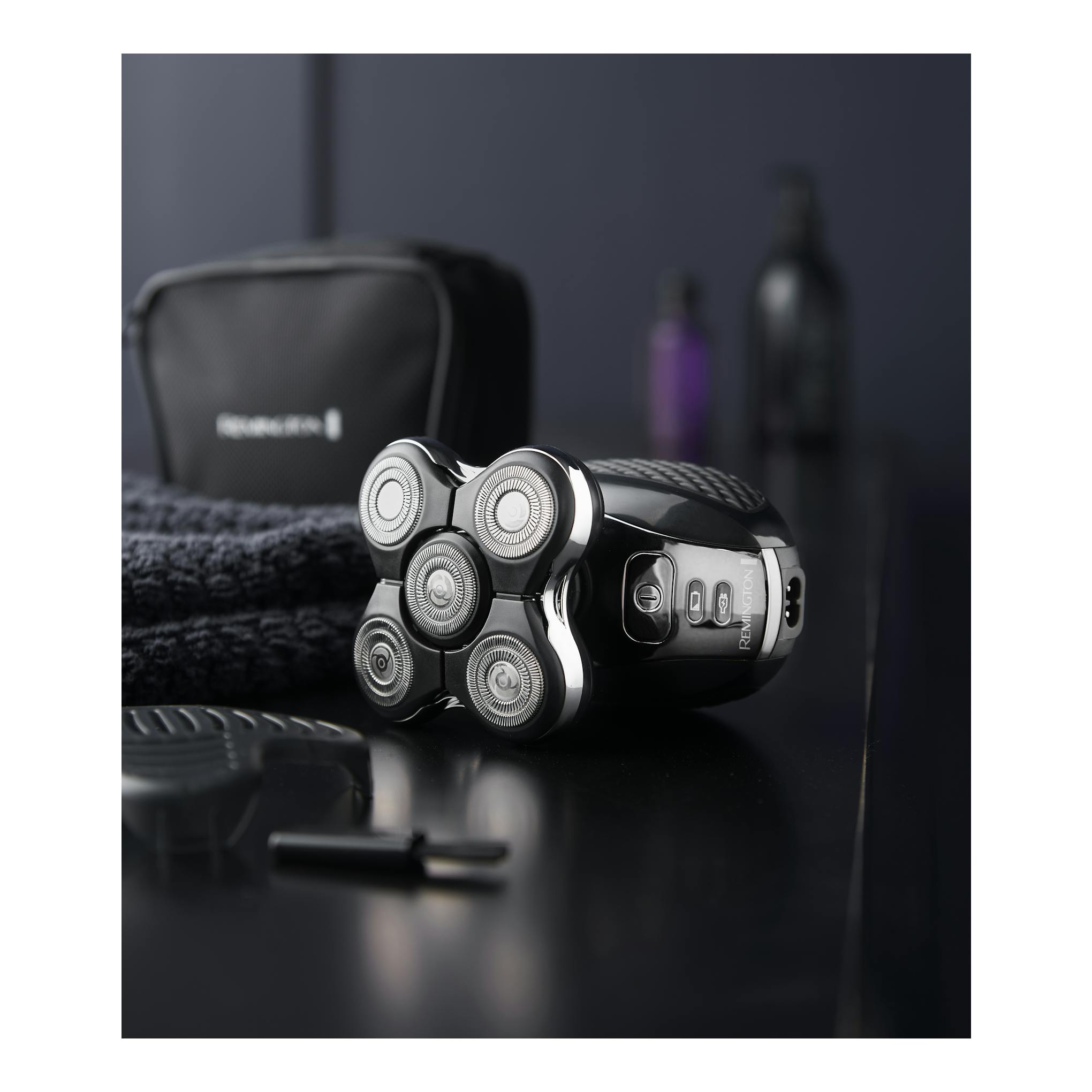 Afeitadora Remington XR1500 negra, vista frontal en ángulo, con 5 cabezales circulares sobre superficie negra.