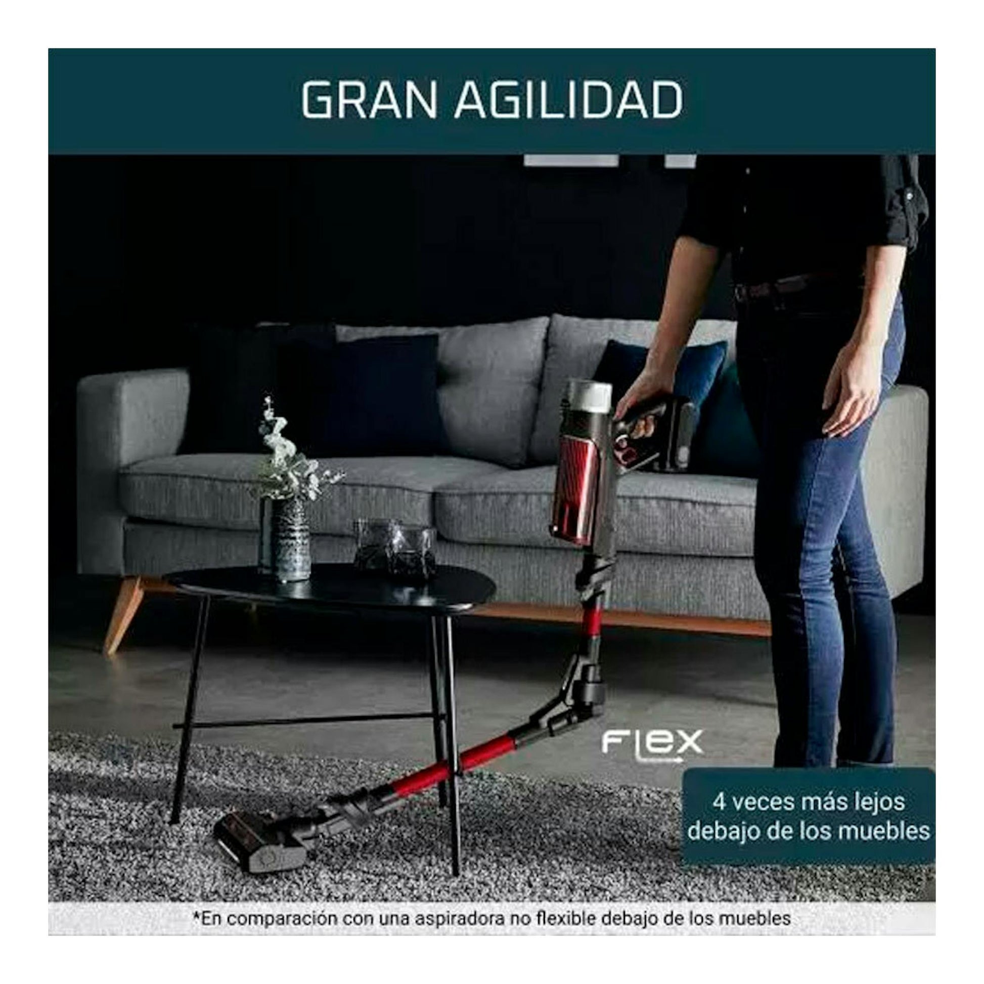Aspirador escoba Rowenta RH2077WO rojo y negro, en uso bajo un sofá, vista lateral en salón.