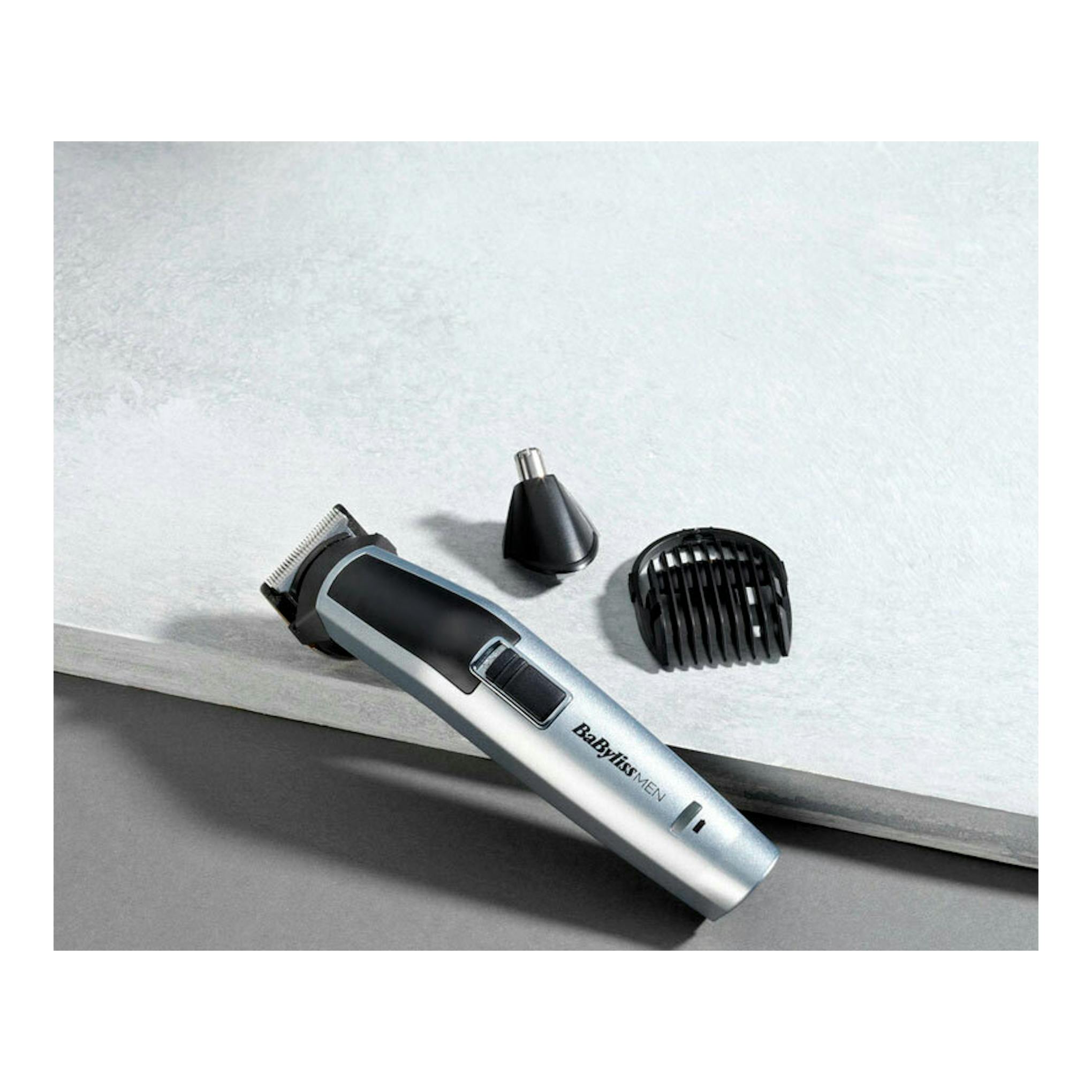 Recortadora Babyliss Men MT725E plateada y negra, vista diagonal, con accesorios y peine guía.