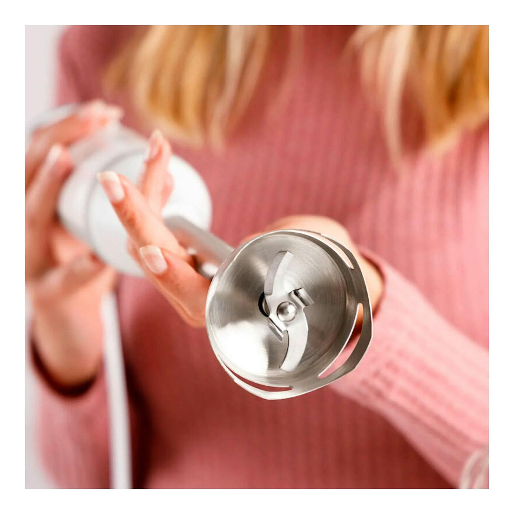 Batidora de mano Taurus Bapi 1200 Pure Plus blanca, con cabezal metálico en primer plano y fondo desenfocado.