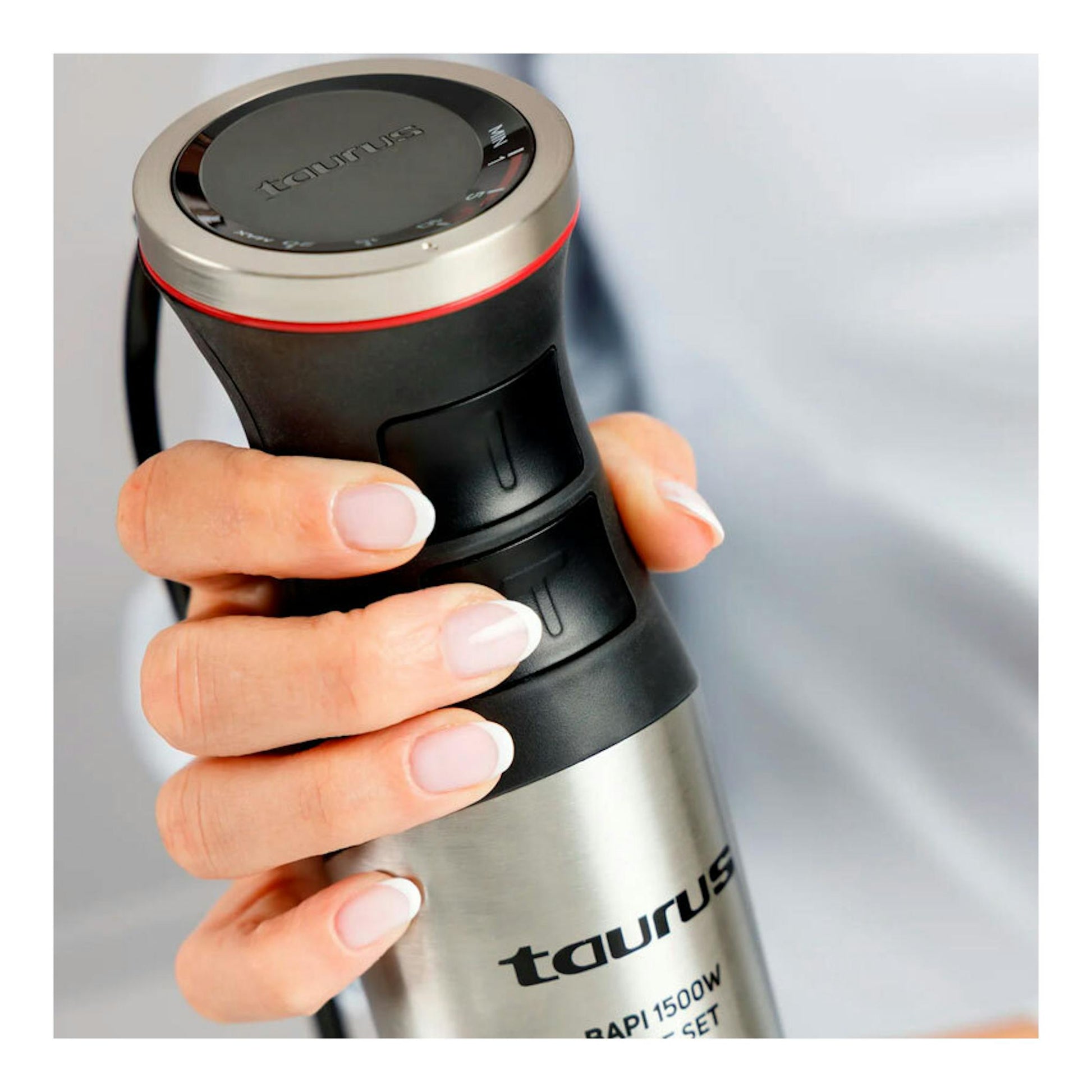 Batidora de mano Taurus Bapi 1500W Inox, vista cercana en mano, cuerpo negro y acero inoxidable.