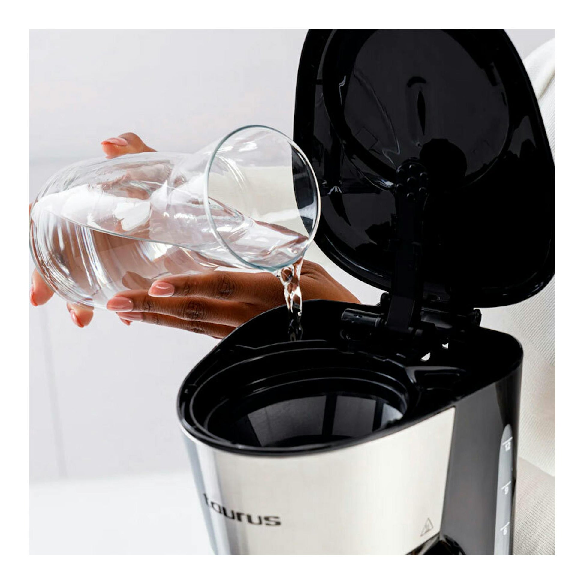 Cafetera de goteo Taurus Verona 12 Inox, vista frontal con tapa abierta, cuerpo inox y negro, llenándose de agua.
