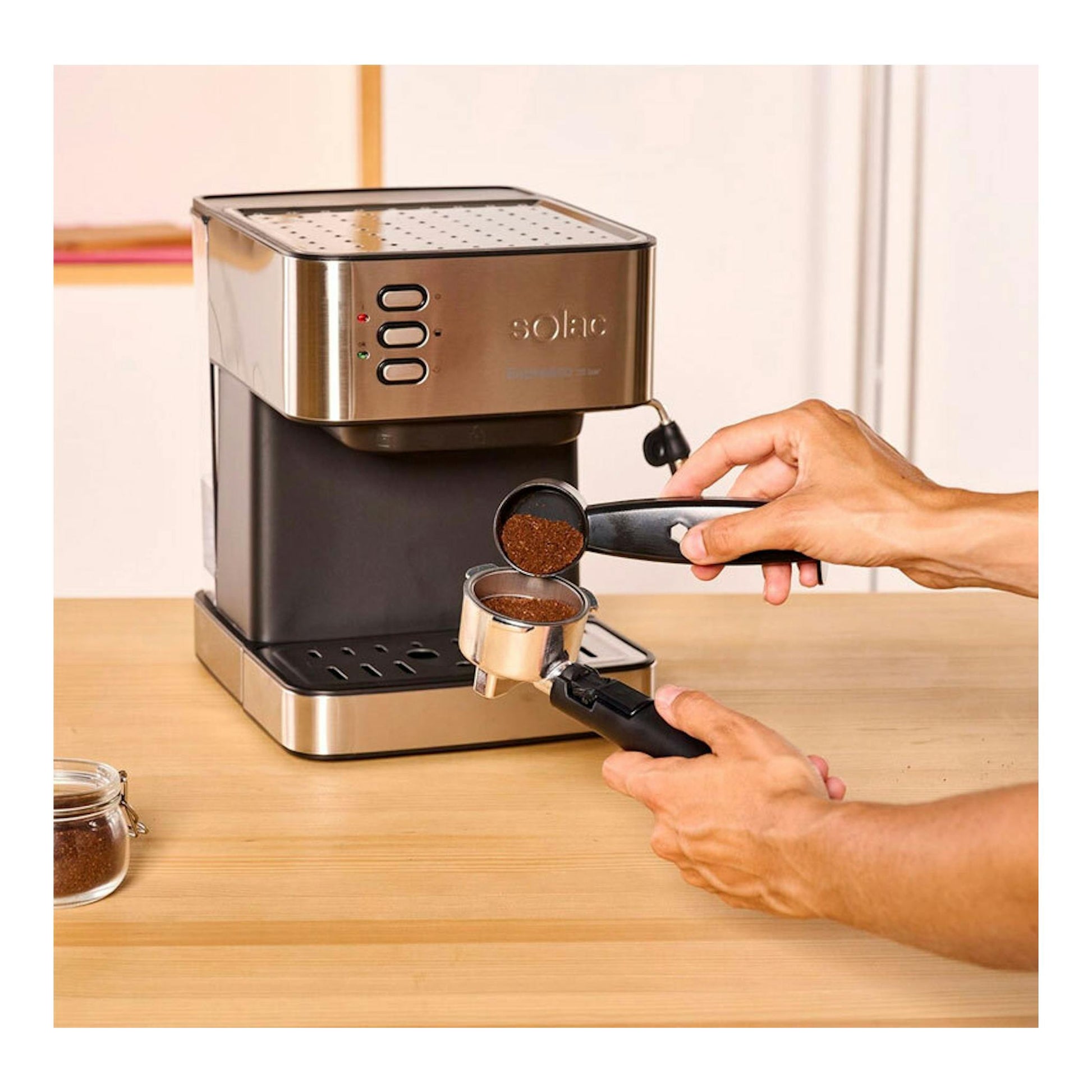Cafetera espresso Solac CE4481 en acero inoxidable y negro, vista frontal, con dos manos llenando el portafiltro.
