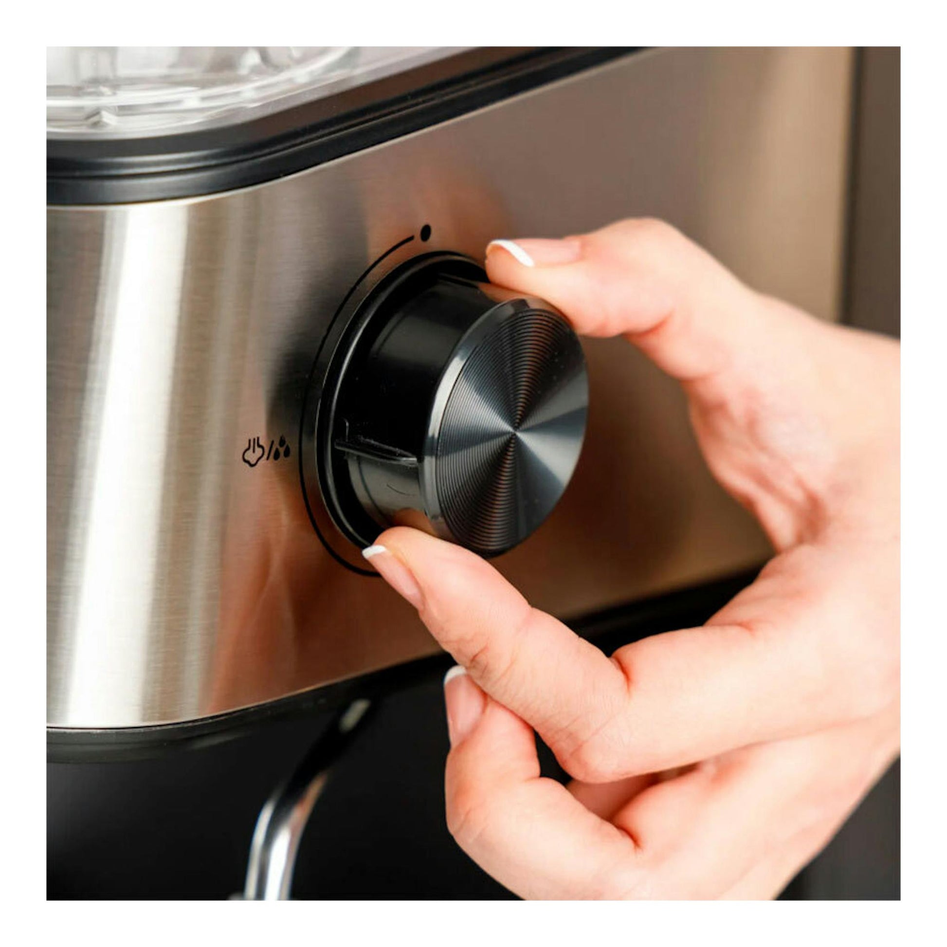 Cafetera espresso Taurus Trento de acero inoxidable, con una mano girando el selector frontal negro.