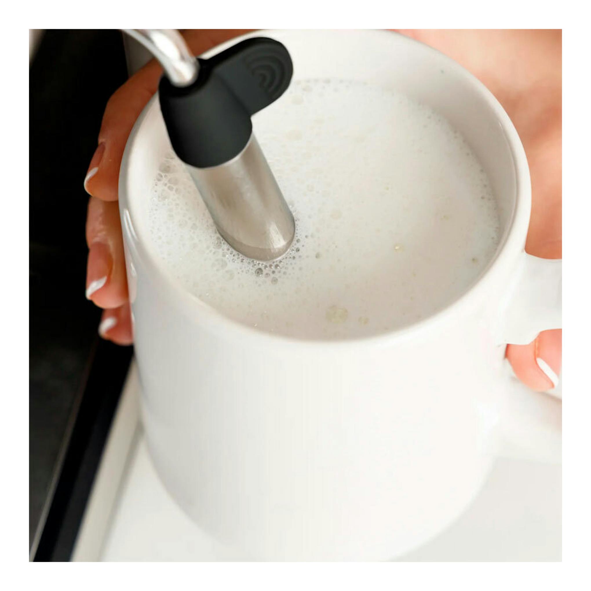 Cafetera expreso Taurus Trento, vista cenital de taza blanca con leche espumada y varilla vaporizadora.