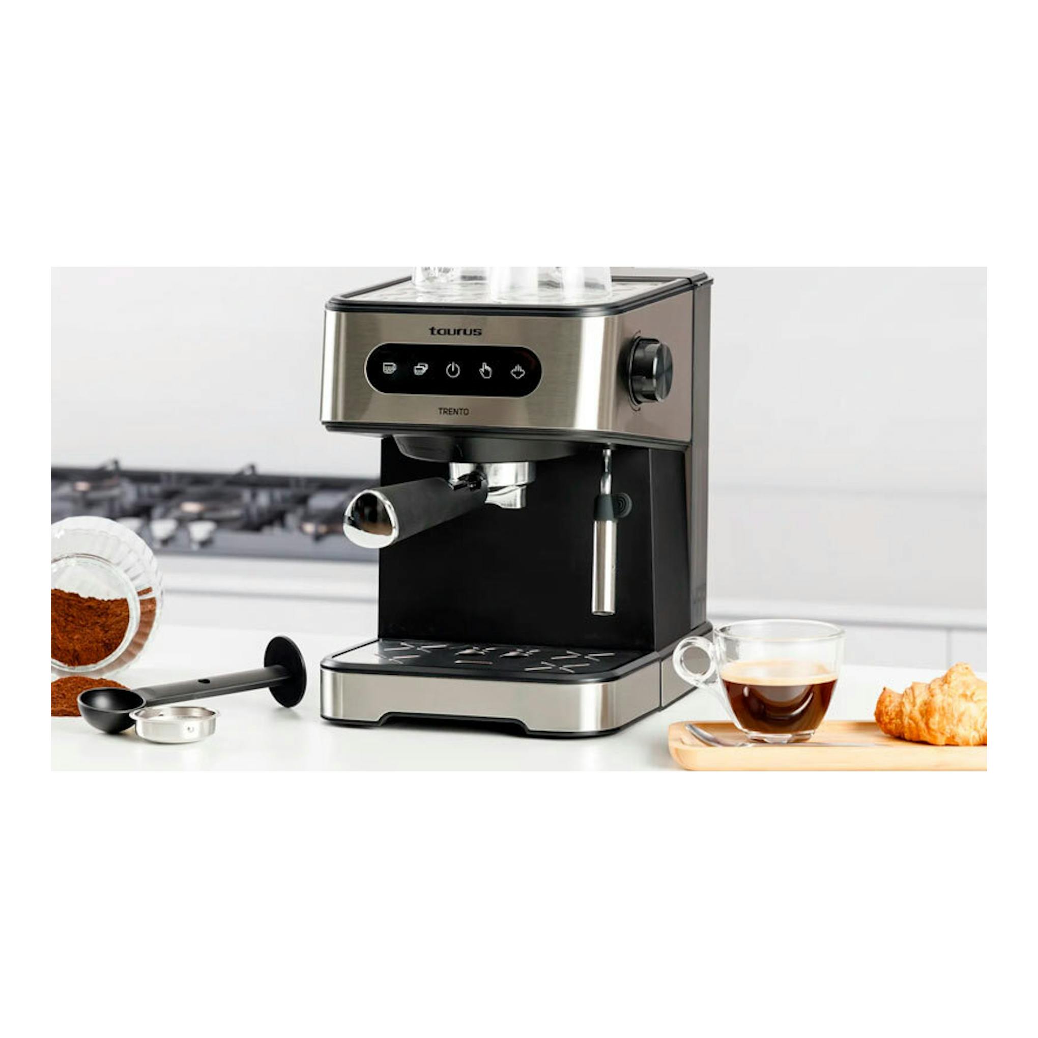 Cafetera espresso Taurus Trento de acero inoxidable y negro, vista frontal tres cuartos, con taza y accesorios.