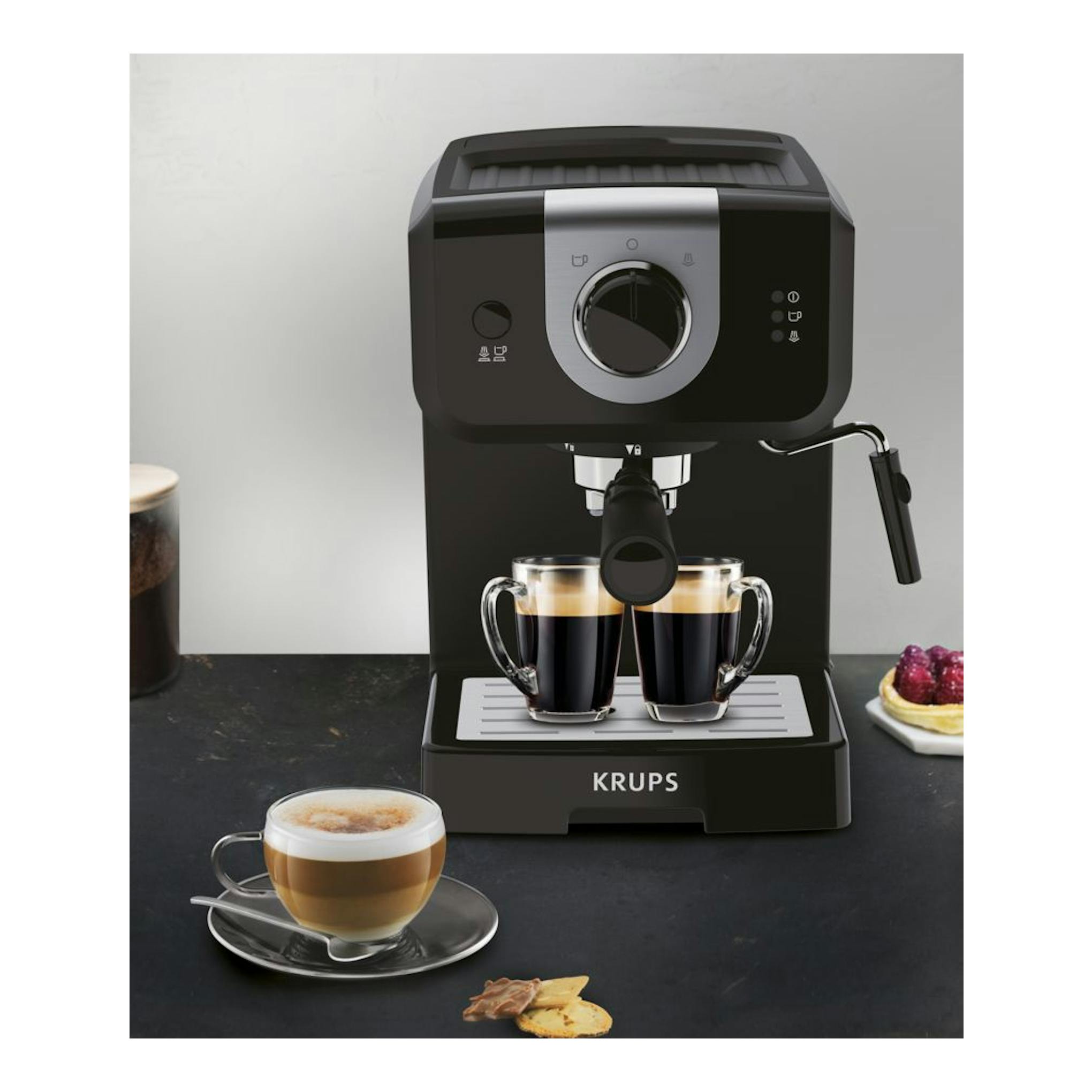 Cafetera espresso Krups OPIO XP320810 negra, vista frontal, con dos tazas y vaporizador lateral.