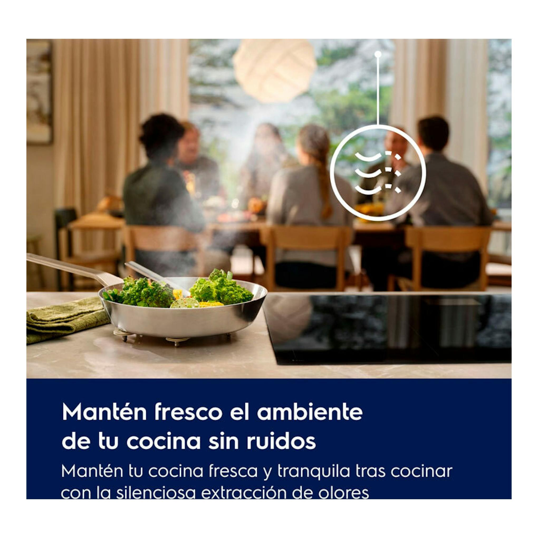 Campana integrable Electrolux LFG815K sobre encimera negra, con vapor de cocción y comedor desenfocado al fondo.