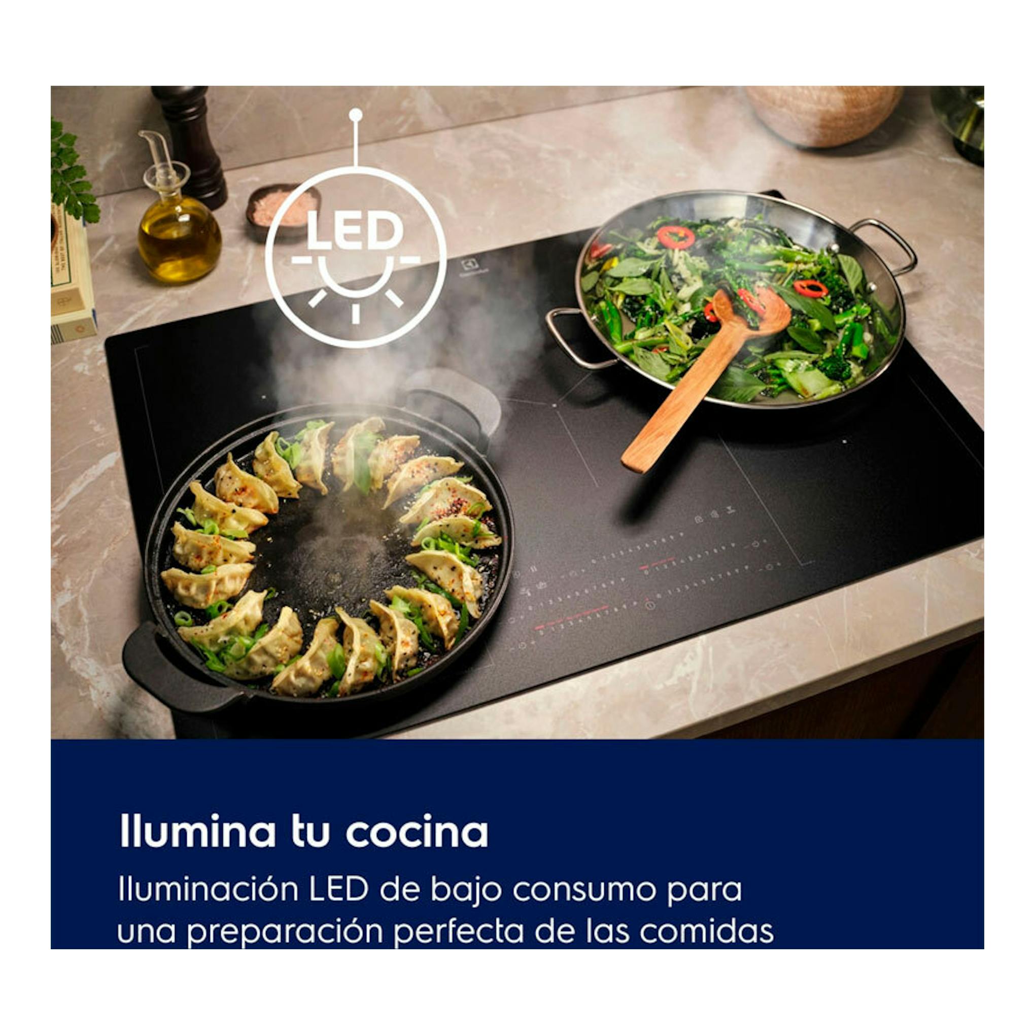Campana integrable Electrolux LFG818K negra sobre cocina, con icono LED y dos sartenes.