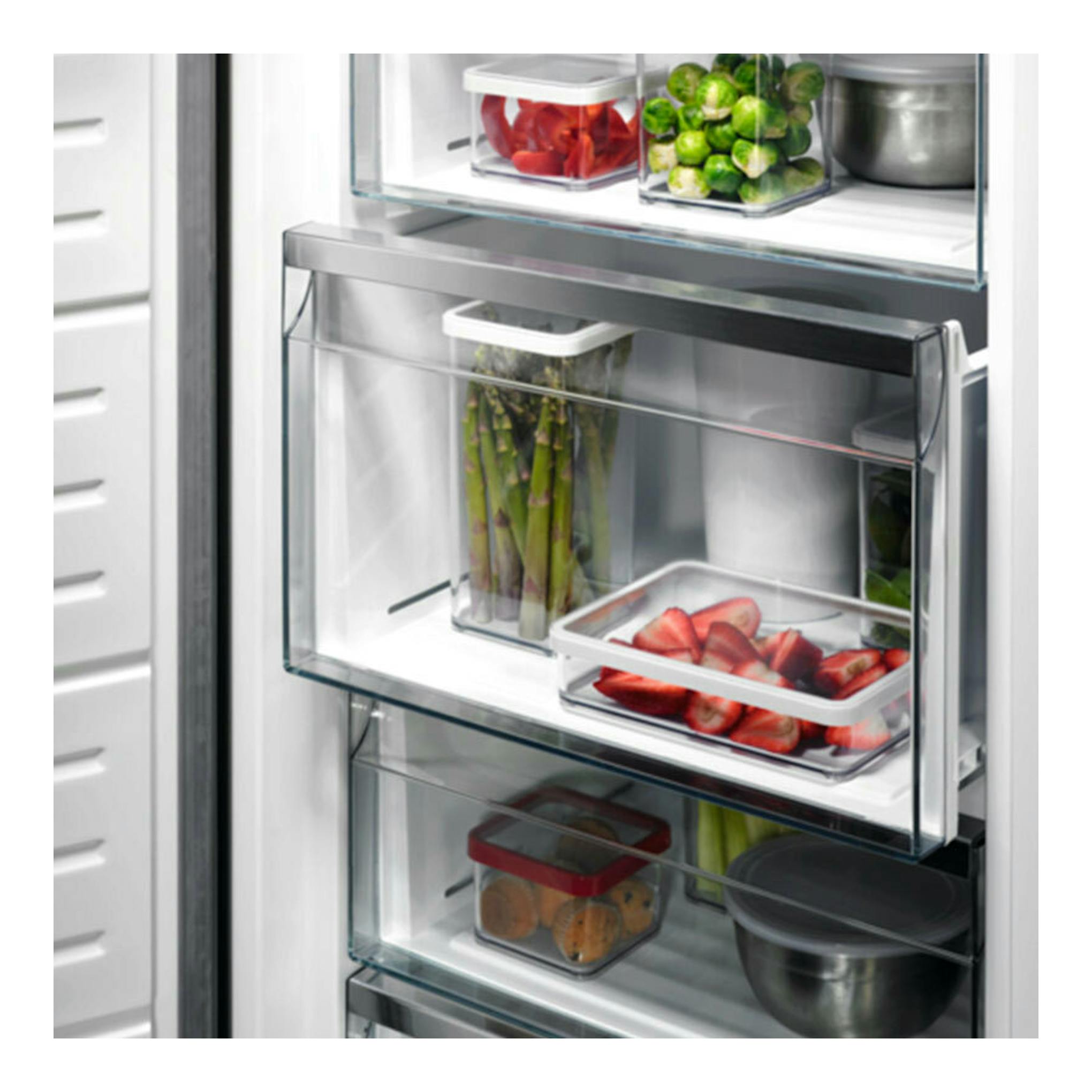 Primer plano del interior de congelador AEG OAG7M281EX inox, con cajones transparentes y alimentos.