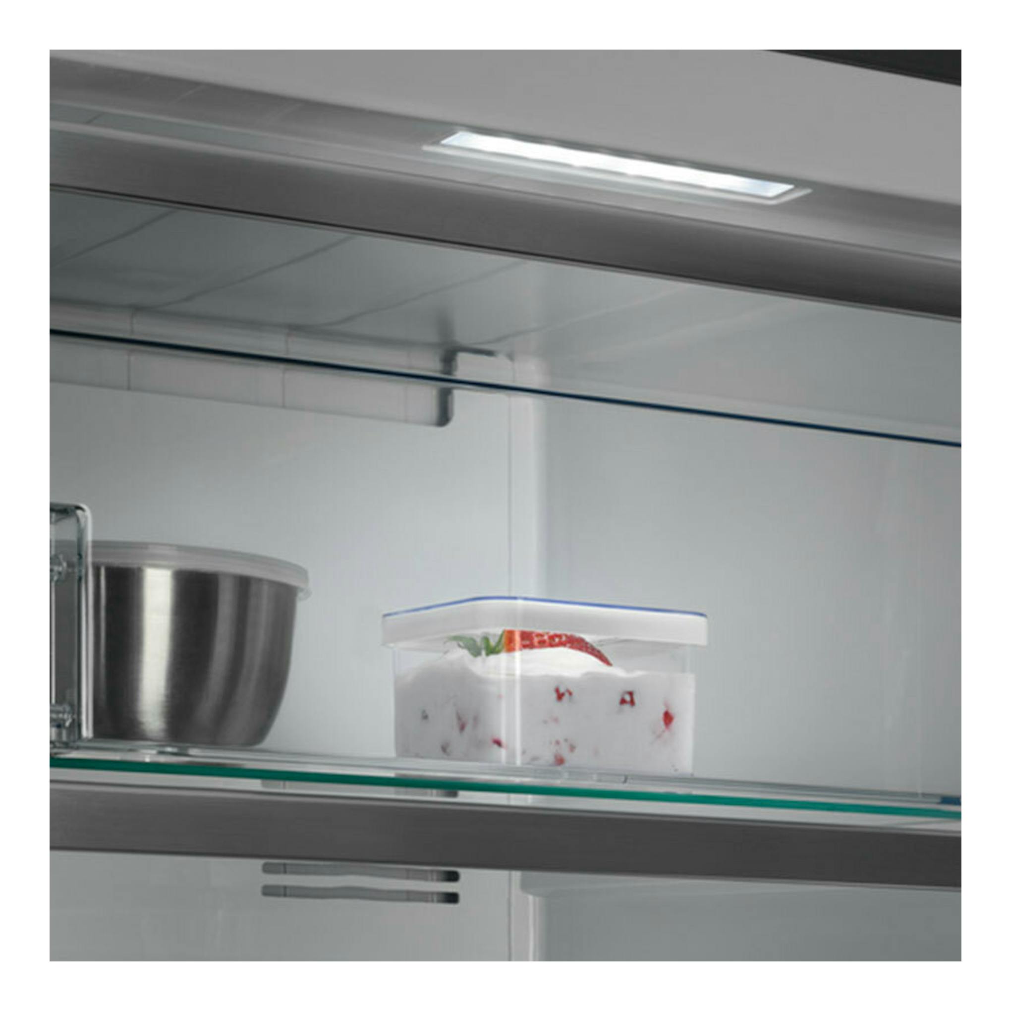 Interior de congelador AEG OAG7M281EX inox, vista interior con estante de cristal y recipientes.