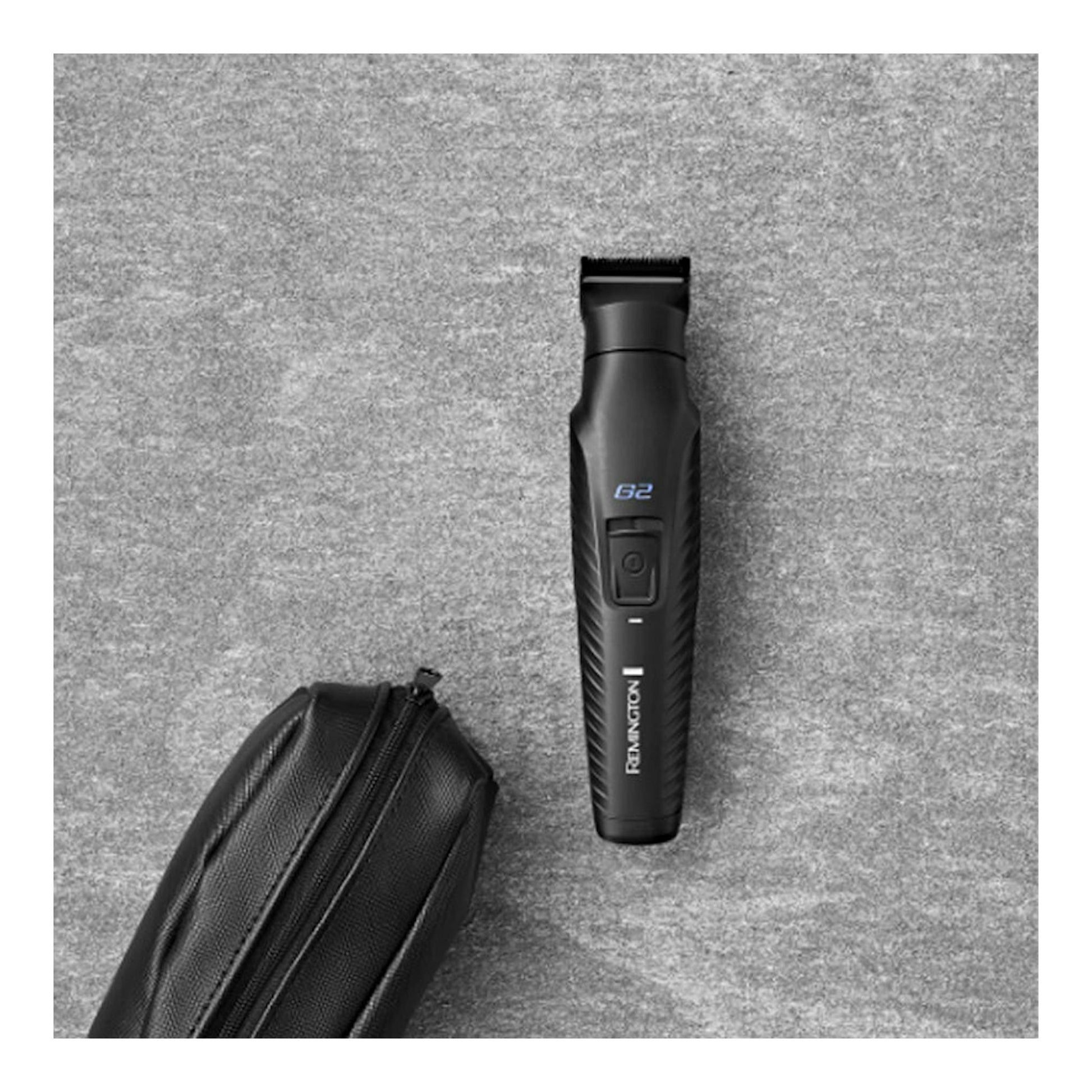 Cortapelos Remington PG2000 negro, vista frontal sobre fondo gris, junto a una funda negra.