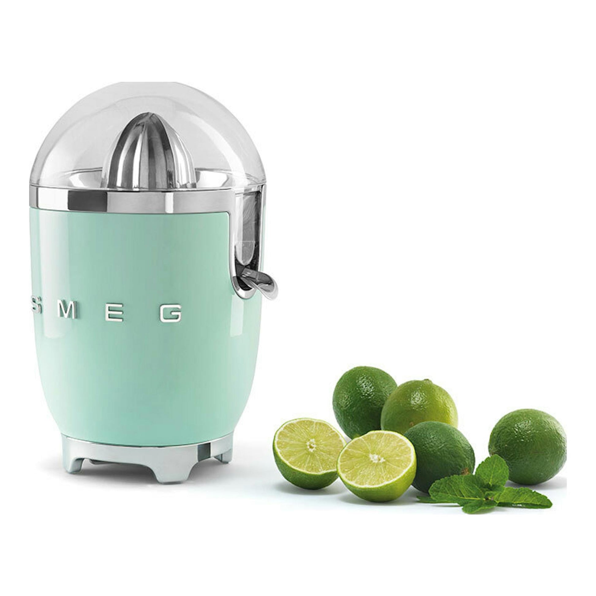 Exprimidor Smeg CJF11PGEU verde menta, vista frontal tres cuartos, junto a limas enteras y partidas.