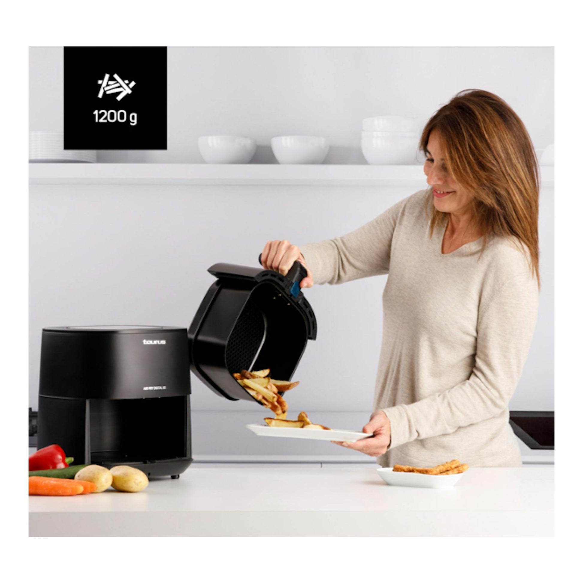 Freidora de aire Taurus Air Fry Digital 6S negra, abierta, vertiendo patatas fritas en una cocina.