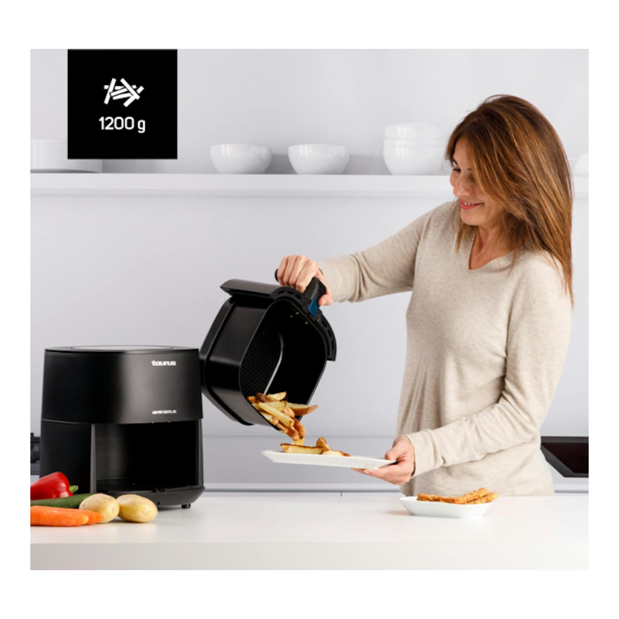 Freidora de aire Taurus Air Fry Digital 6S negra, abierta, vertiendo patatas fritas en una cocina.