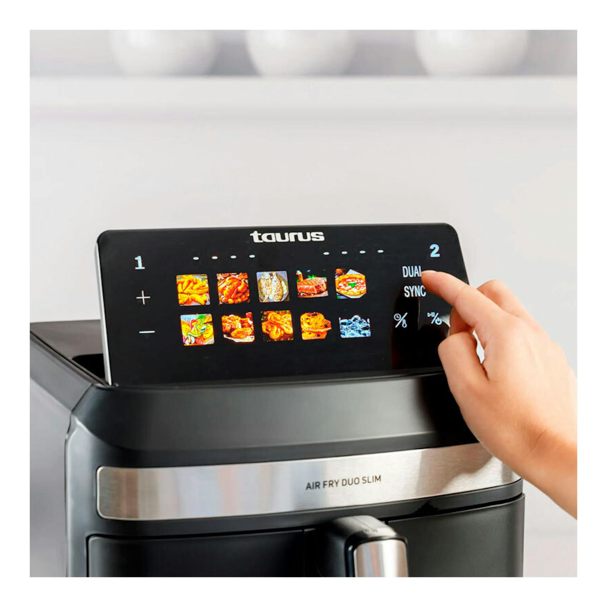 Freidora de aire Taurus Duo Slim negra, vista frontal, con panel táctil y una mano tocando la pantalla.