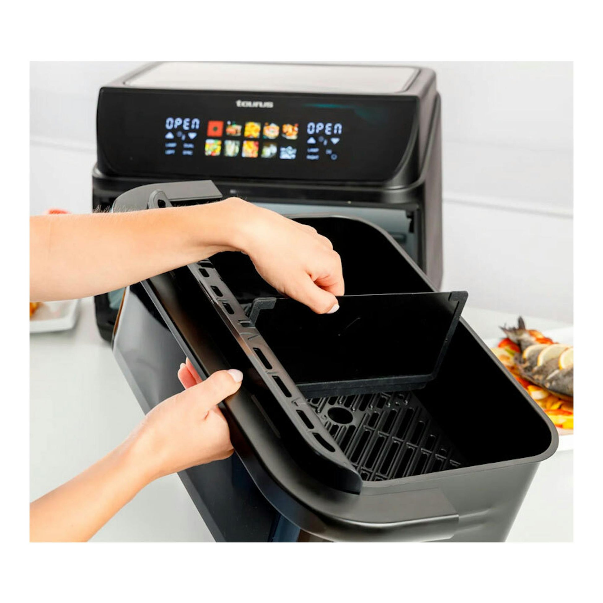 Freidora de aire Taurus Grill 360 negra, vista frontal en 3/4, con cesta extraíble abierta.