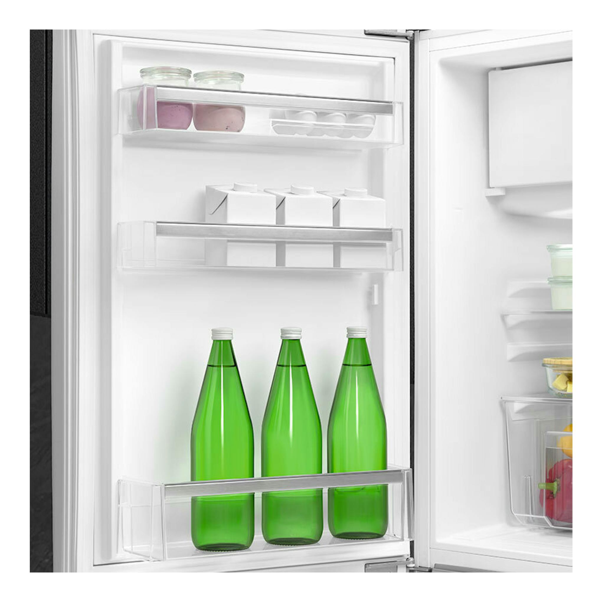 Interior de frigorífico Smeg FAB10LWH6 blanco, vista frontal, con botellas verdes y estantes transparentes.