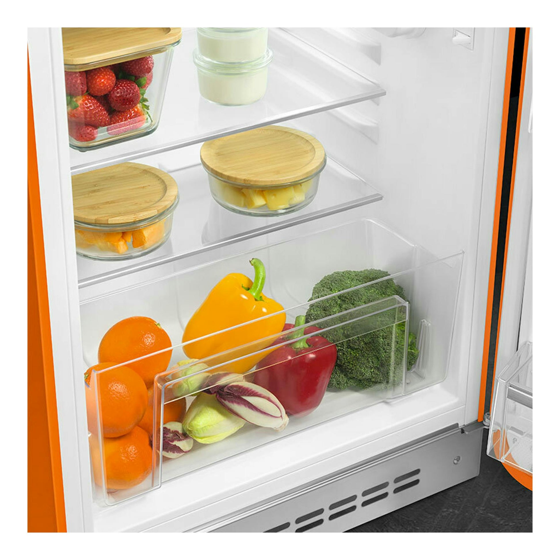 Interior de frigorífico Smeg FAB10ROR6 naranja, con estantes de vidrio, cajón y alimentos frescos.