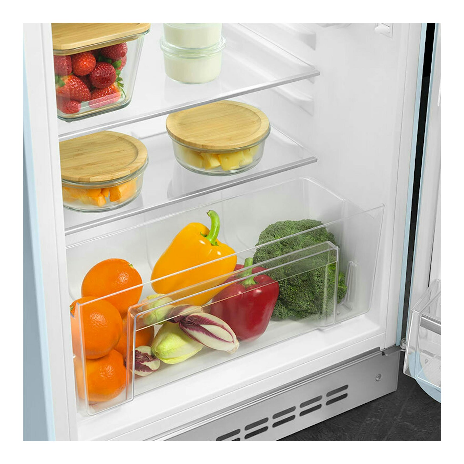 Interior de frigorífico Smeg FAB10RPB6, vista frontal, con estantes de vidrio, cajones y frutas y verduras.