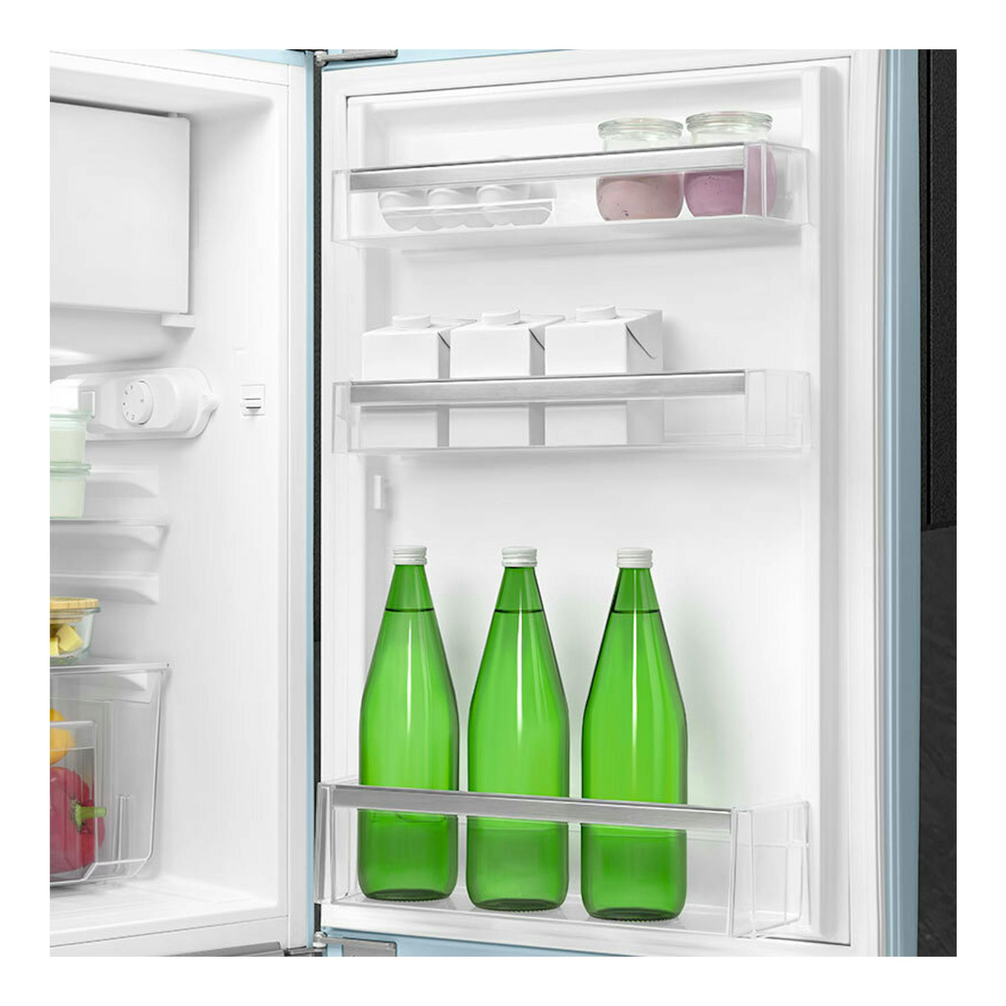 Interior de frigorífico Smeg FAB10RPB6 azul, puerta abierta, con botellas verdes y estantes transparentes.