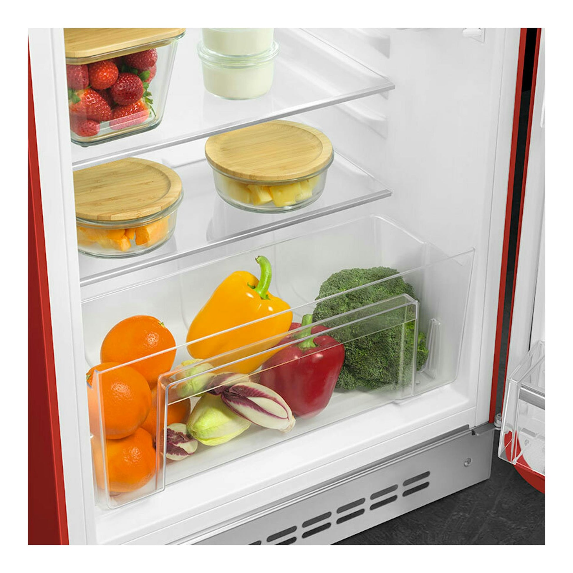 Interior de frigorífico Smeg FAB10RRD6 rojo, con estantes de vidrio y cajón con fruta y verduras.