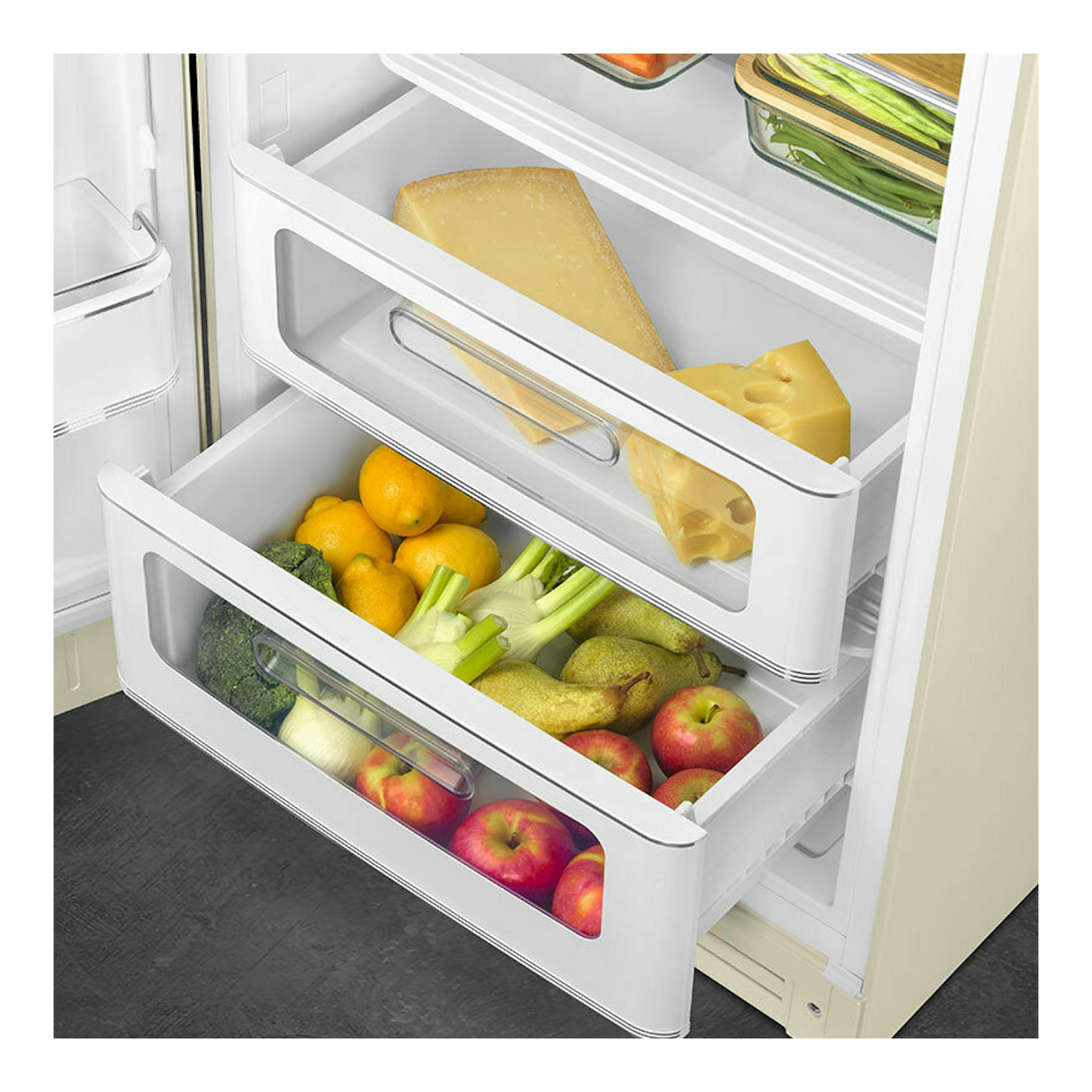 Vista en ángulo del interior de un frigorífico Smeg FAB28LCR6 crema, con cajones abiertos, fruta, verduras y queso.