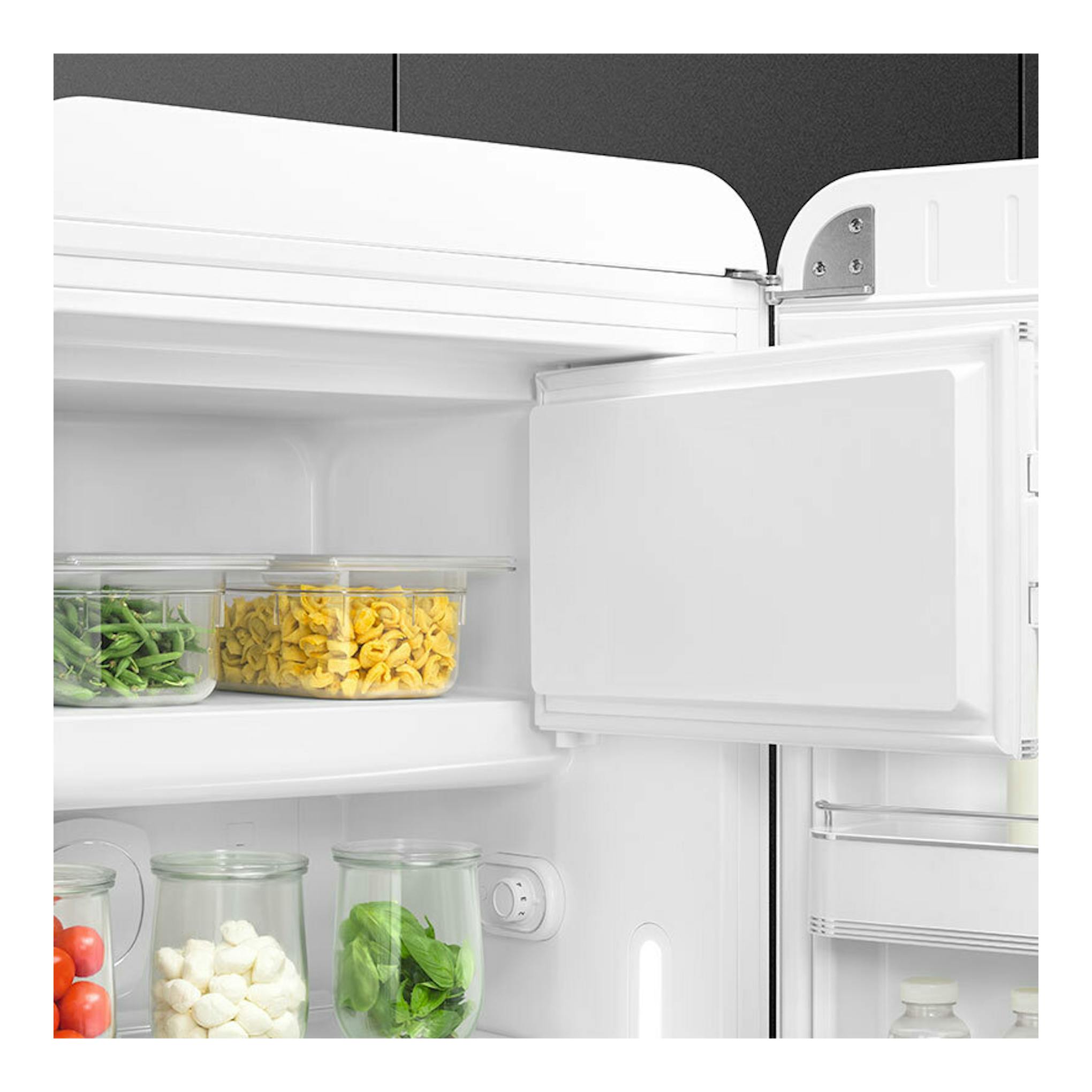 Interior de frigorífico Smeg FAB28RWH6 blanco, puerta abierta, con estantes y recipientes con alimentos.