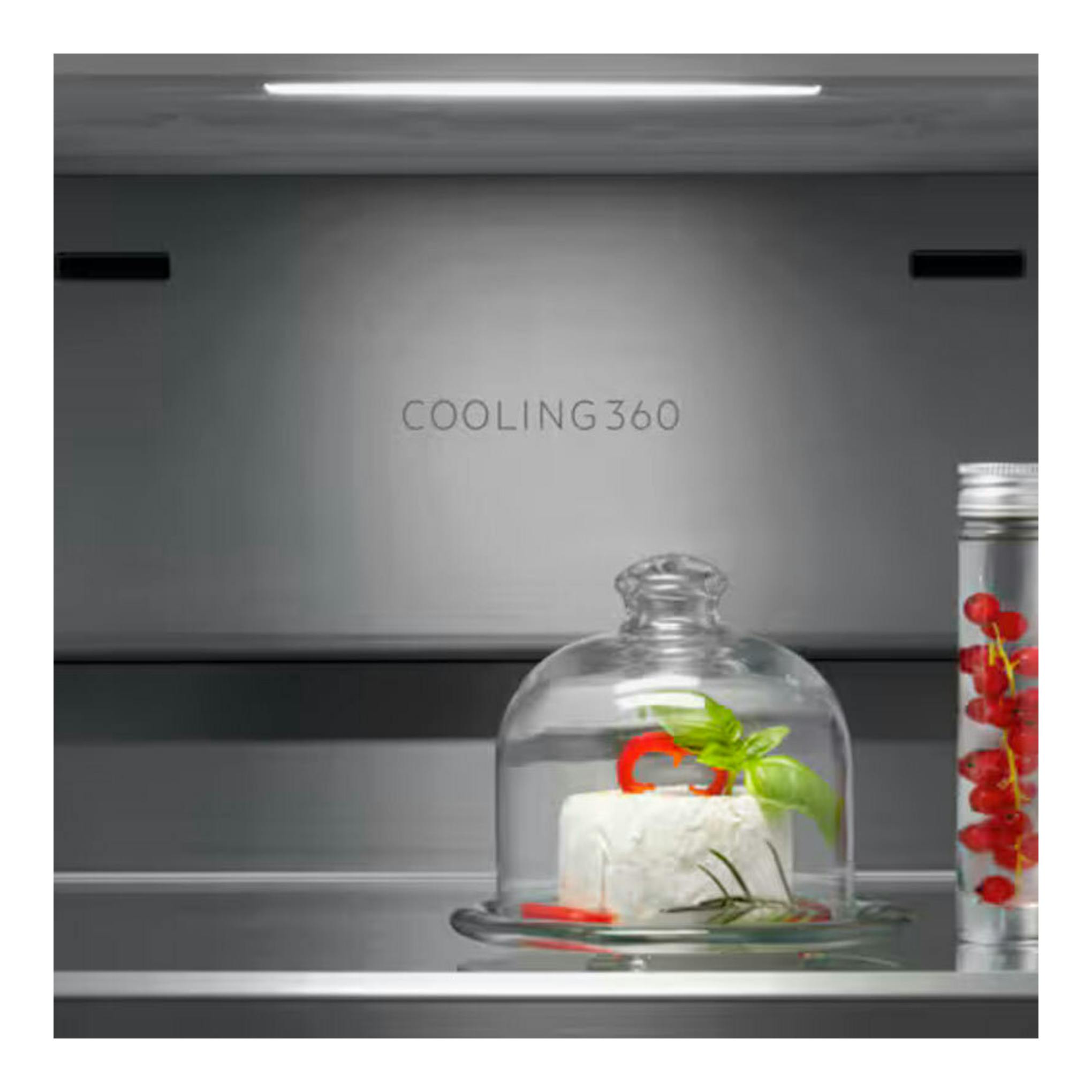 Interior de frigorífico AEG ORX9V351DU inox, con queso bajo campana y frasco con frutos rojos.