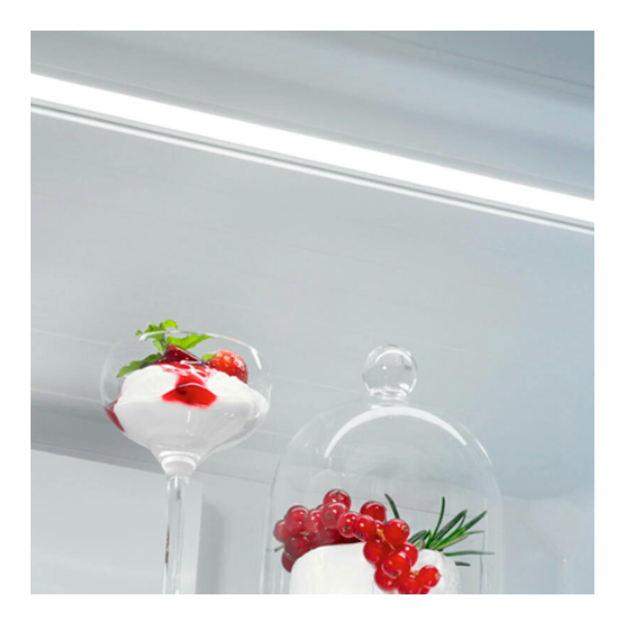 Interior de frigorífico AEG ORC6M481EX inox con copas de postre, frutos rojos y campana de cristal.