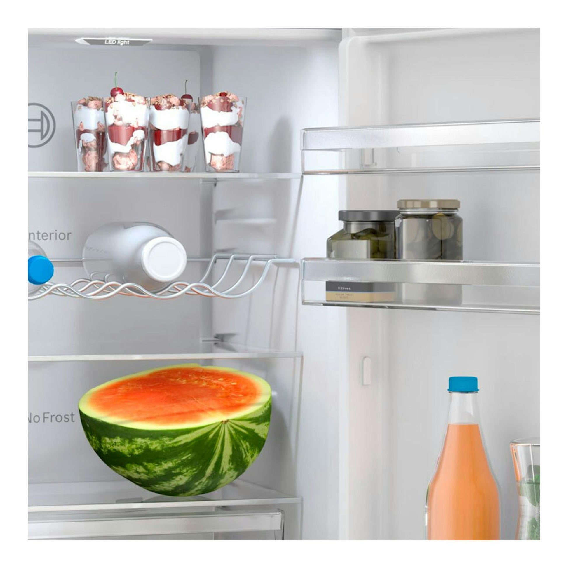 Interior de frigorífico combi Bosch KGN362WCF blanco, vista frontal con estantes, botellas y media sandía.