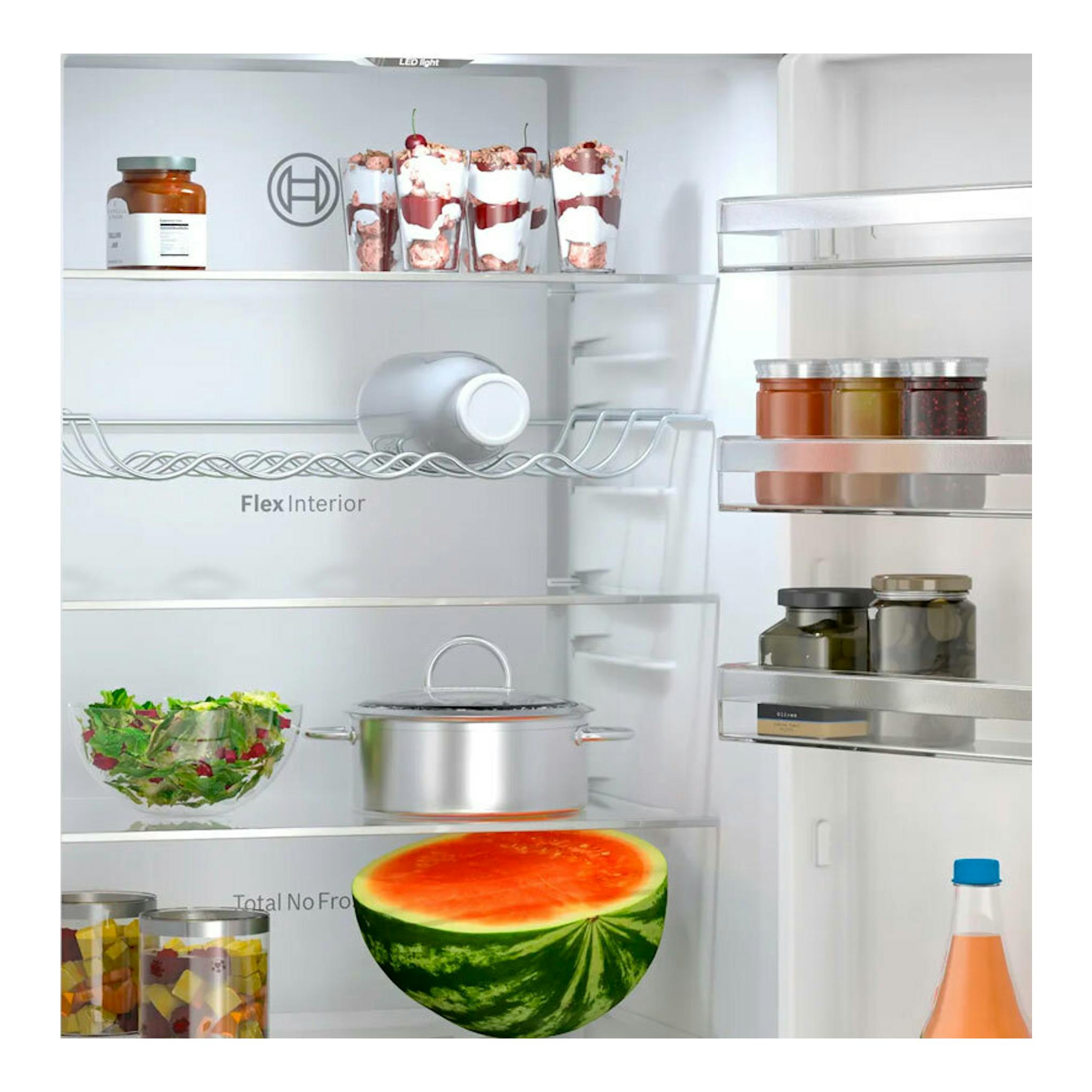 Interior de frigorífico combi Bosch KGN392LAG inox, vista frontal, con estantes de cristal y alimentos.