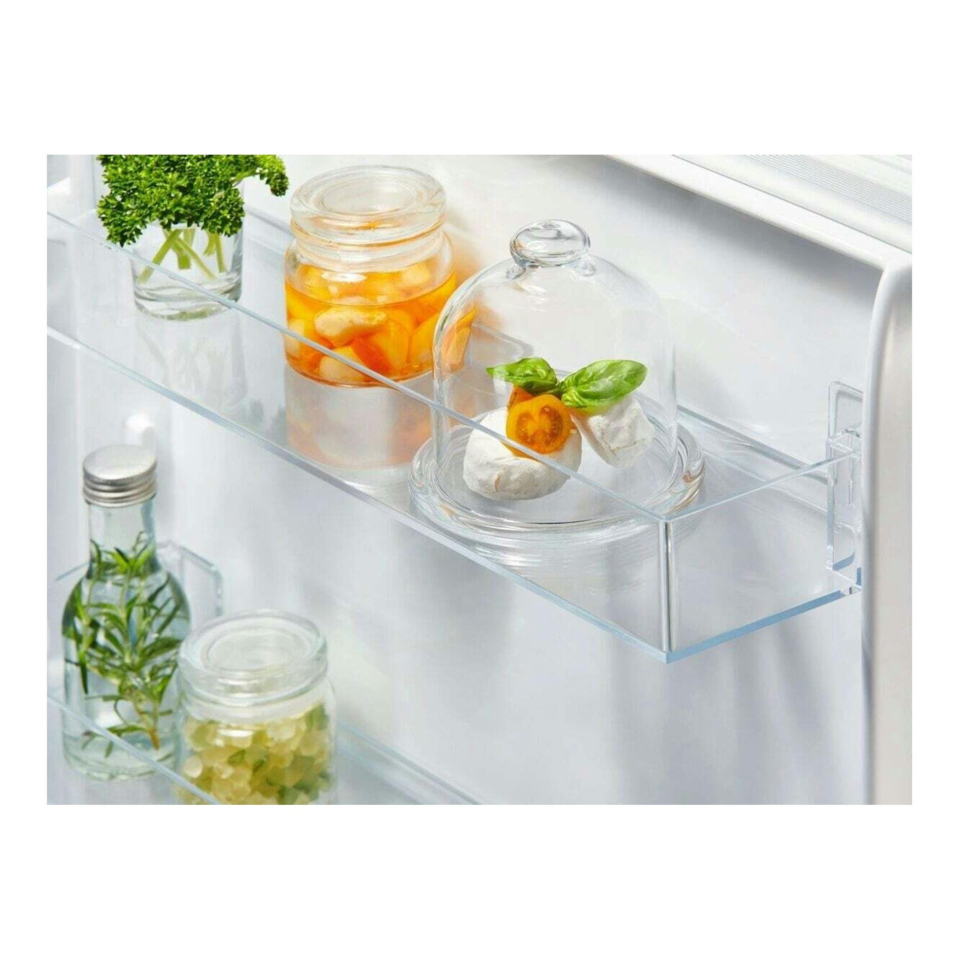 Vista interior frontal de frigorífico combi Electrolux LNA6DE18S, con estantes de vidrio y tarros de comida.