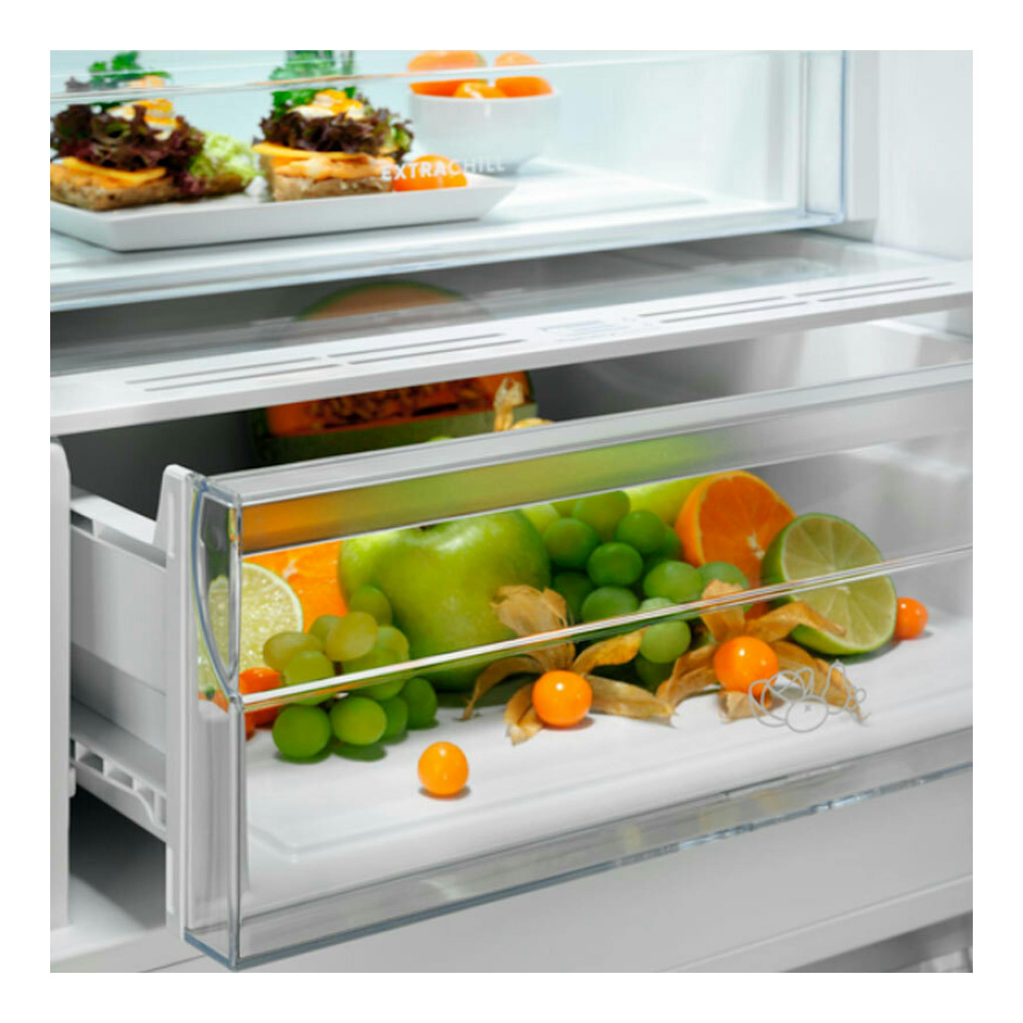 Interior de frigorífico combi Electrolux LNT6ME32U2 inox, con cajón transparente y fruta, vista frontal.