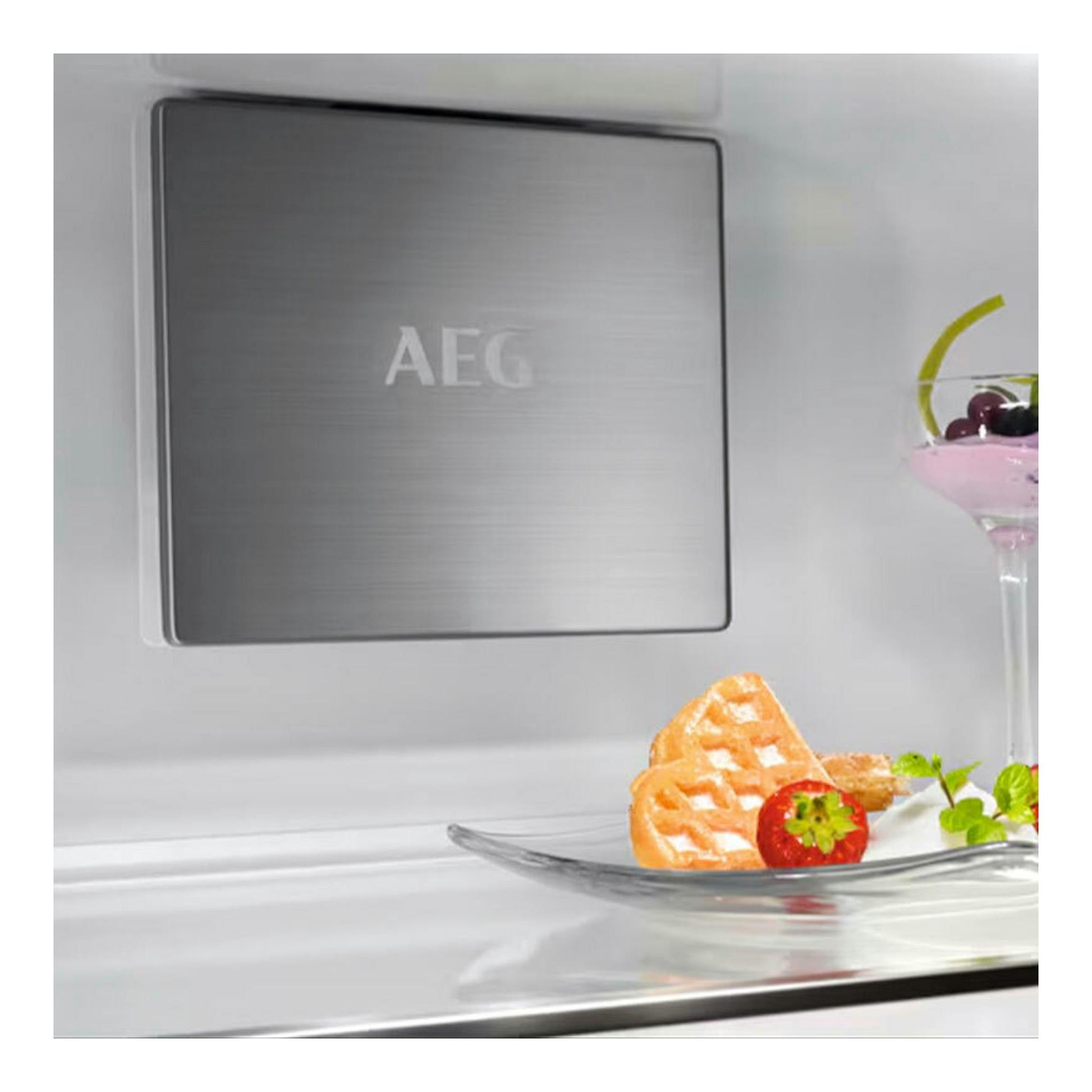 Interior de frigorífico integrable AEG NSC7P751ES, vista frontal del panel gris con logo AEG y estante de cristal.