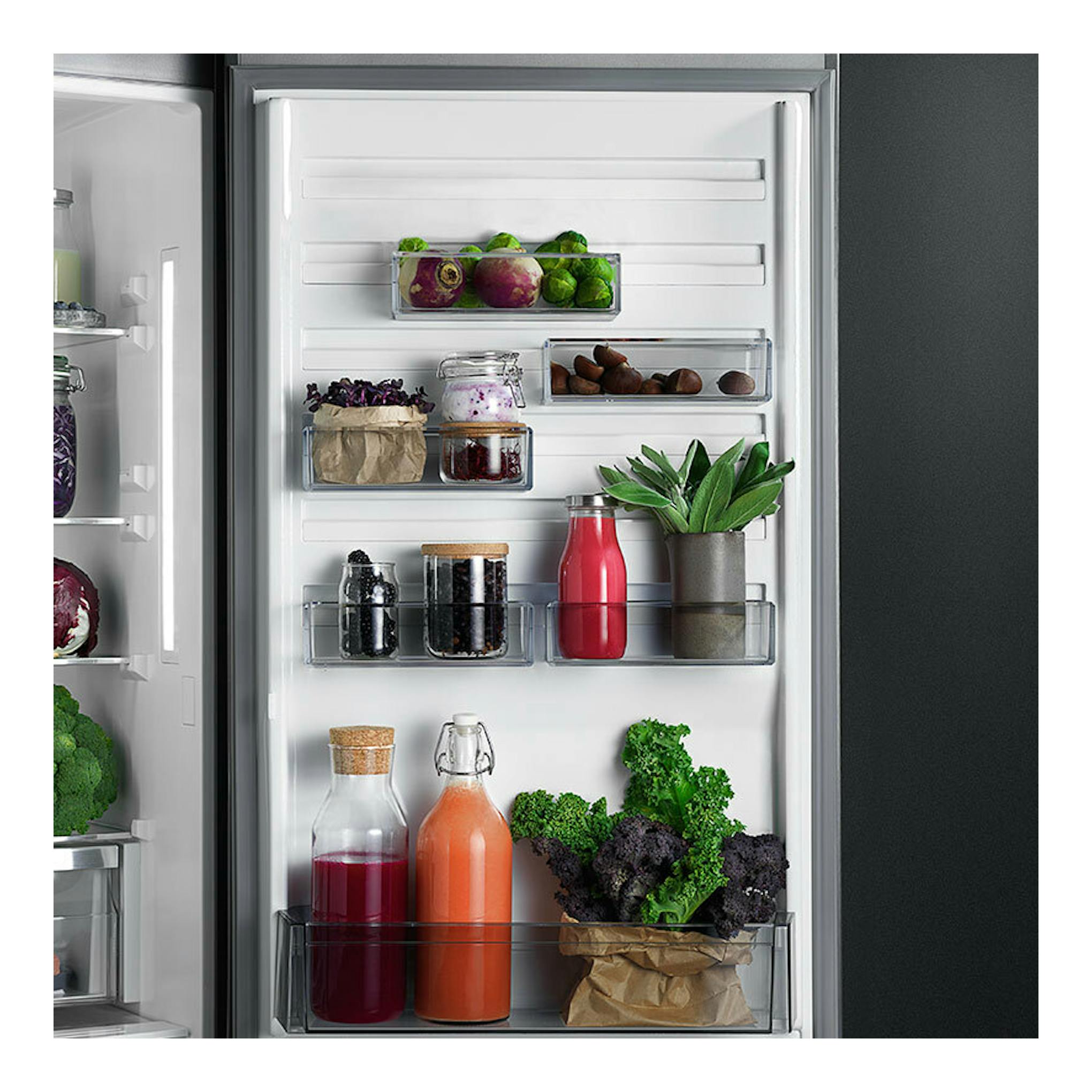 Interior de la puerta de un frigorífico integrable AEG TC6MS19FES, vista frontal, con botellas, tarros y verduras.