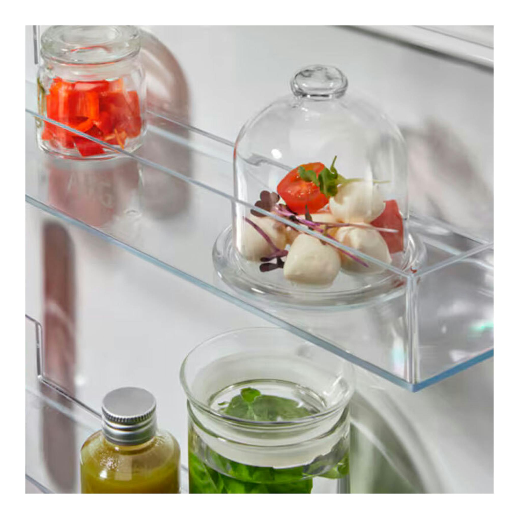 Interior de frigorífico integrable AEG TC7CS181ES, con estantes de cristal y recipientes con comida.
