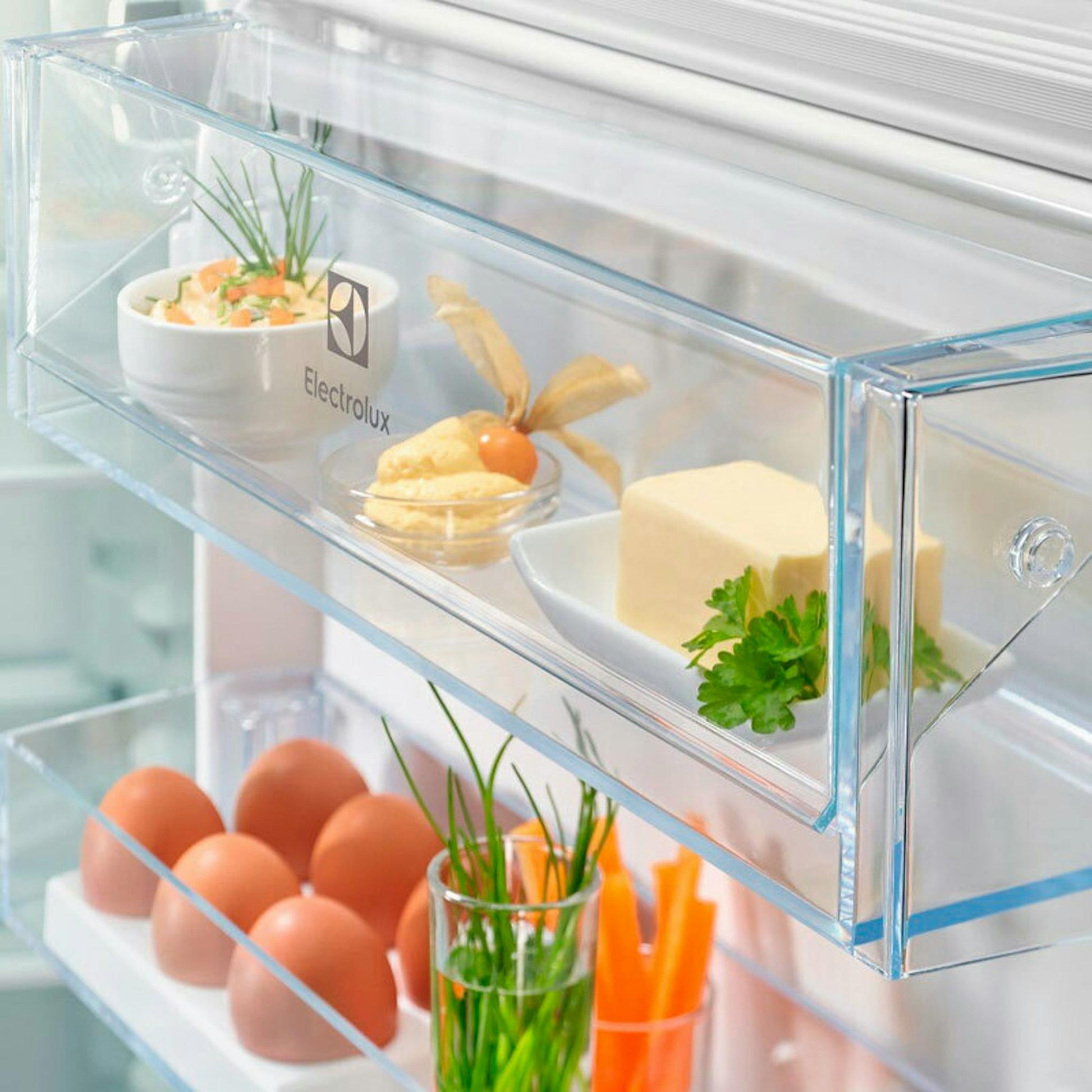 Interior del frigorífico combi integrable Electrolux ENT6NE18S con estantes y alimentos