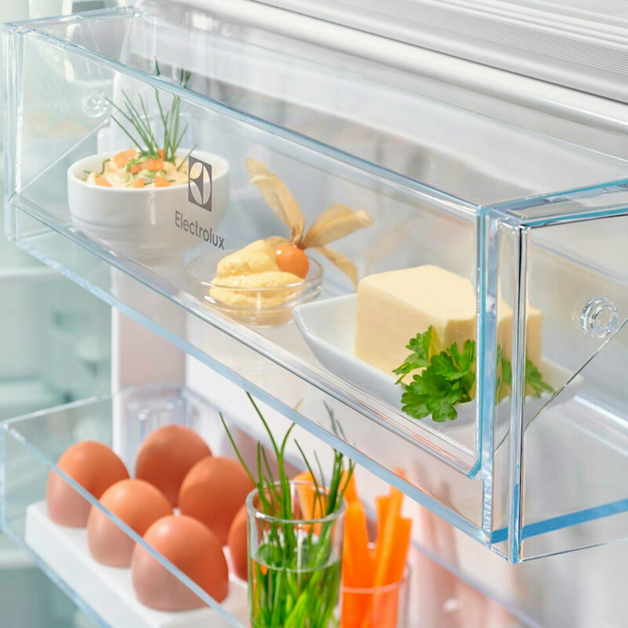 Interior del frigorífico combi integrable Electrolux ENT6NE18S con estantes y alimentos