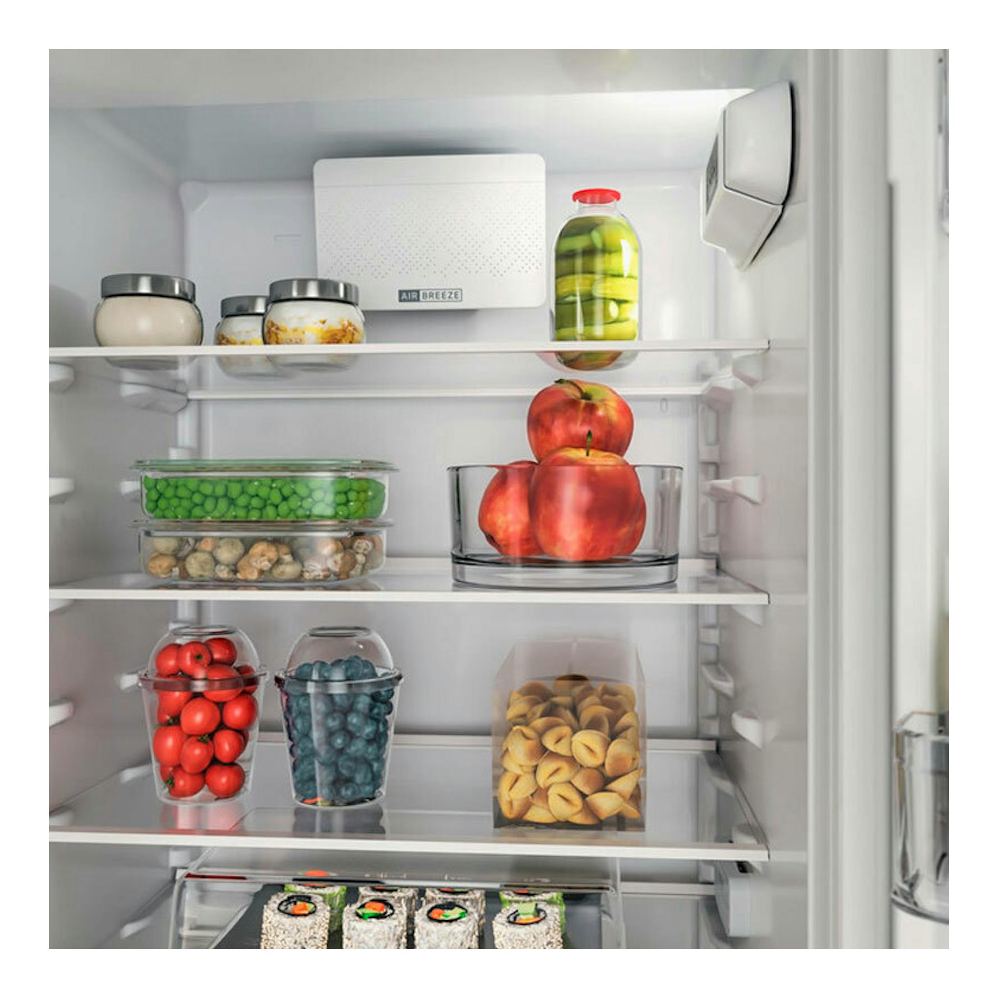 Interior de frigorífico combi integrable Whirlpool WHC18D031A1, con estantes y alimentos vistos de frente.