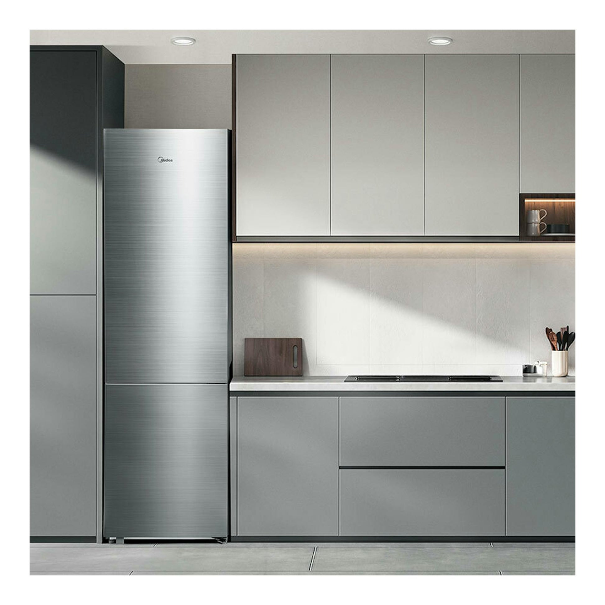 Frigorífico combi Midea MDRB600MME46 inox, vista frontal, junto a muebles grises de cocina moderna.